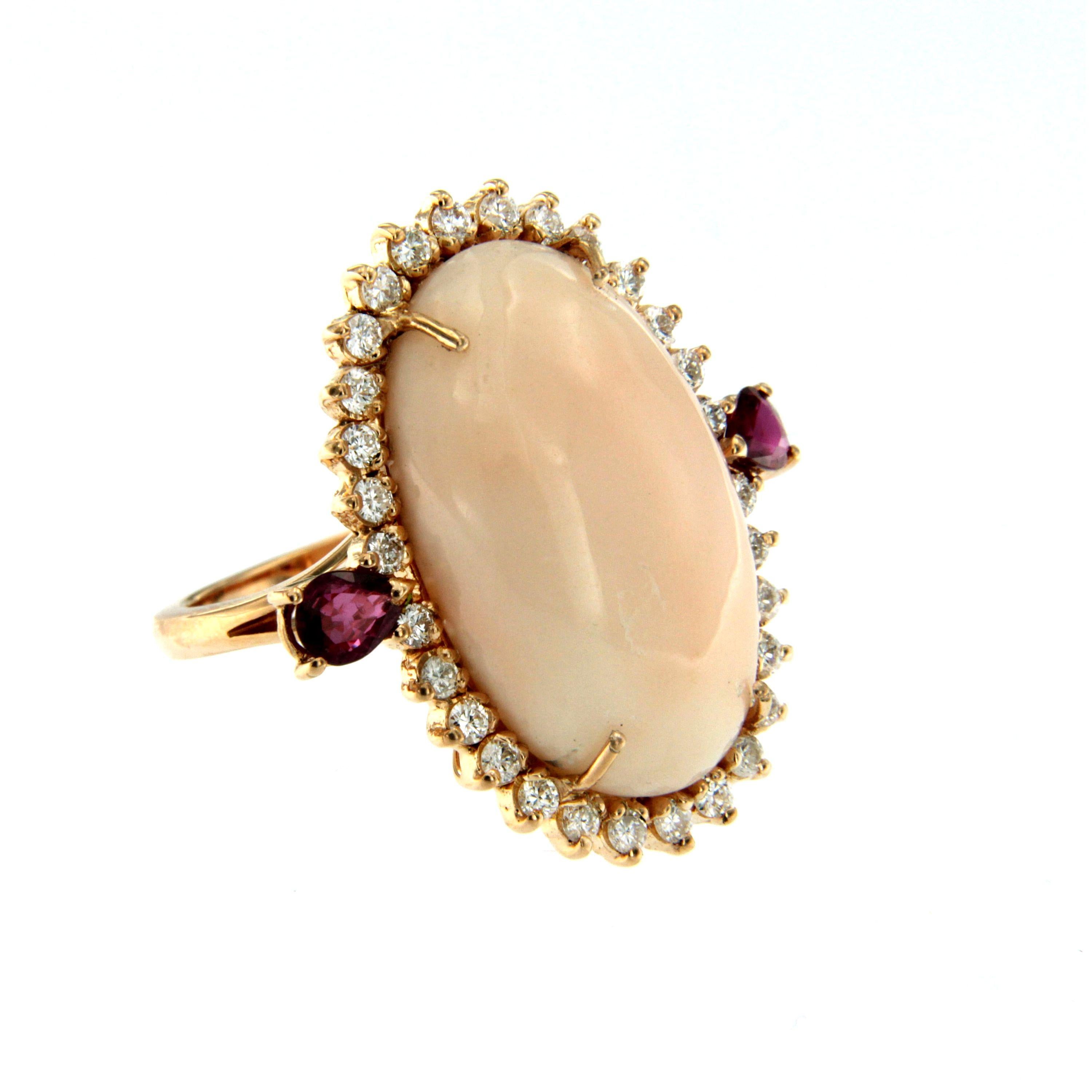 Beautiful Retro Cocktail Ring mounted in 18k rose gold set with a natural, of great quality, Peau D'Ange/Angel skin Coral  24.56 x 16 mm and surrounded by 0.60 carat of Round brilliant cut diamonds graded G color Vvs clarity and two beautiful fine