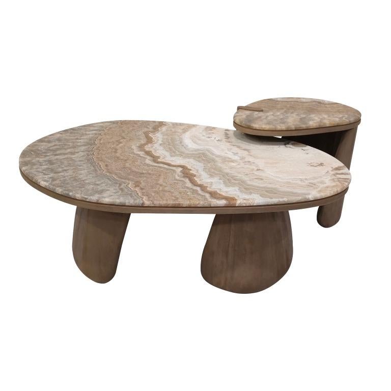 an artisanal coffee table that is designed to capture the natural profile of stone pebbles. with a precious caramel onyx from turkey and an organic curling base crafted entirely in solid timber, this signature piece is designed to enlighten any