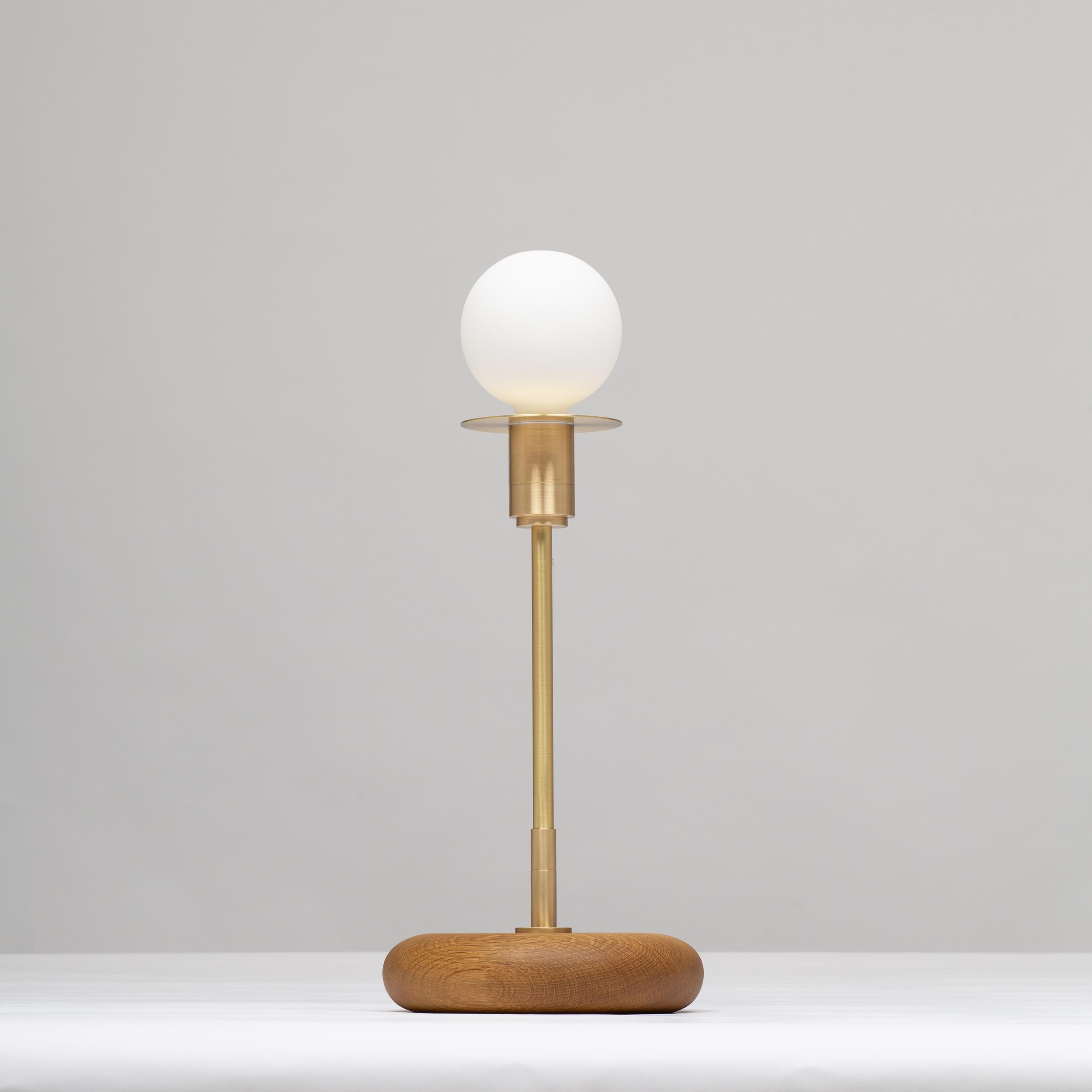 Handturned English Smoked Oak Pebble Table Lamp. Pure Monocoat natural oil finish.
Solid brass, Satin finish. Spun Brass Disc. Lacquered. 
Inline LED dimmer. Linen Fabric Cable.
2000K - 2800K  95CRI
600 Dim to Warm Lumens
Sphere III bulb included
MK