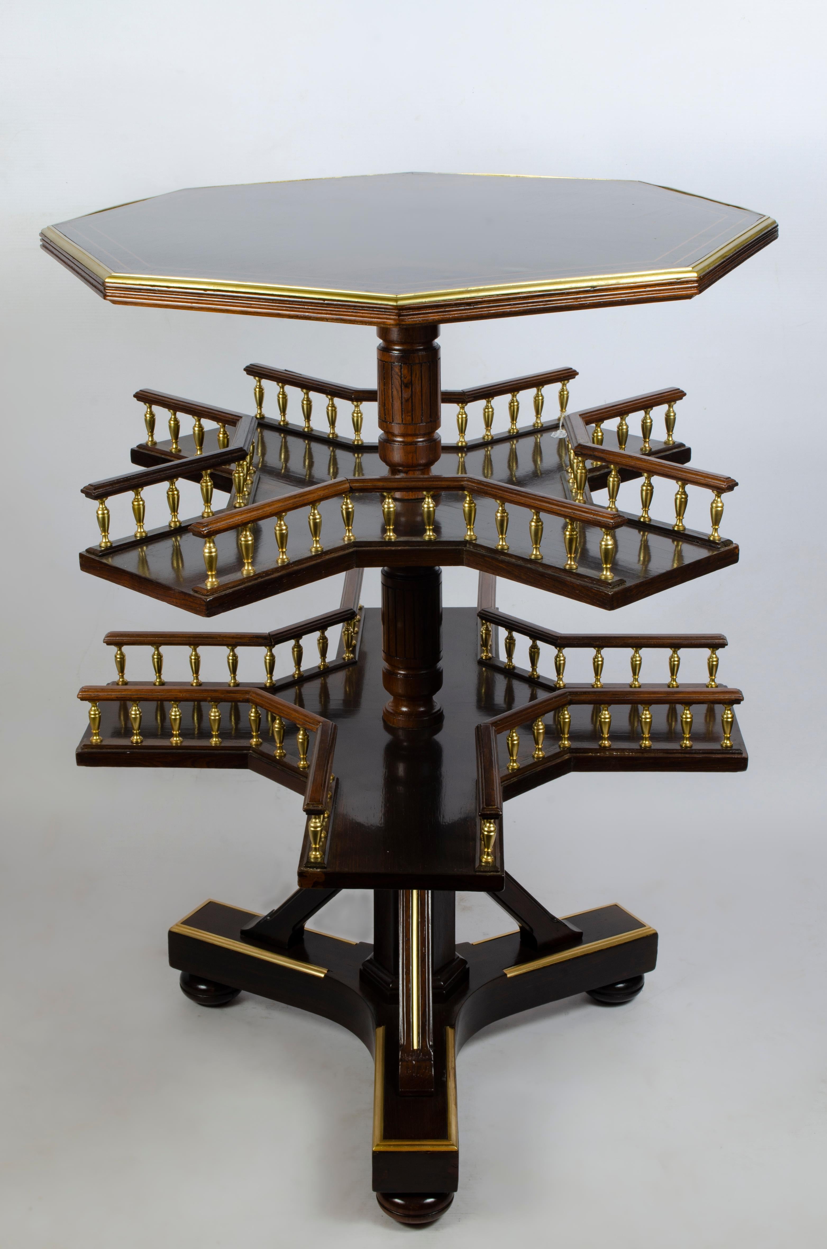 Peculiar French book table, by Paul Sormani (1817-1877). Signed Paul Somani, 10 Charlot, Paris.

Made of rosewood veneered wood. Octagonal shaped lid. Fruit wood fillets. Two revolving shelves with turned bar rails, with gilt