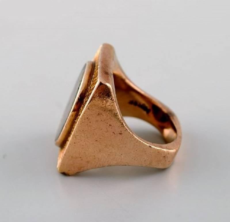 Peder Musse: Ring of 14 kt. gold with petrified wood.
Danish jeweler.
Stamped.
In very good condition.
Size 16,2 mm. Size (USA) 6. Our jeweler can adjust to any size for an additional $50.