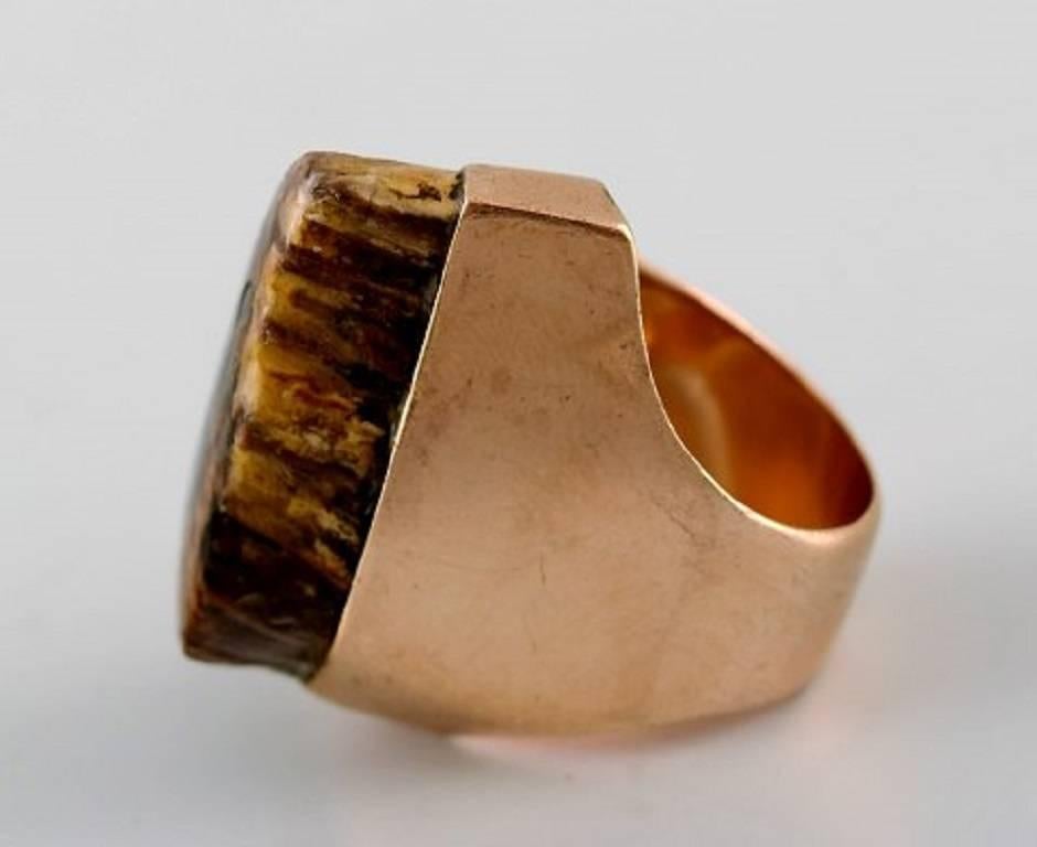 Peder Musse: Ring of 14 kt. gold with petrified wood.
Danish jeweler.
Stamped.
In very good condition.
Size 16,2 mm. Size (USA) 6. Our jeweler can adjust to any size for an additional $50.