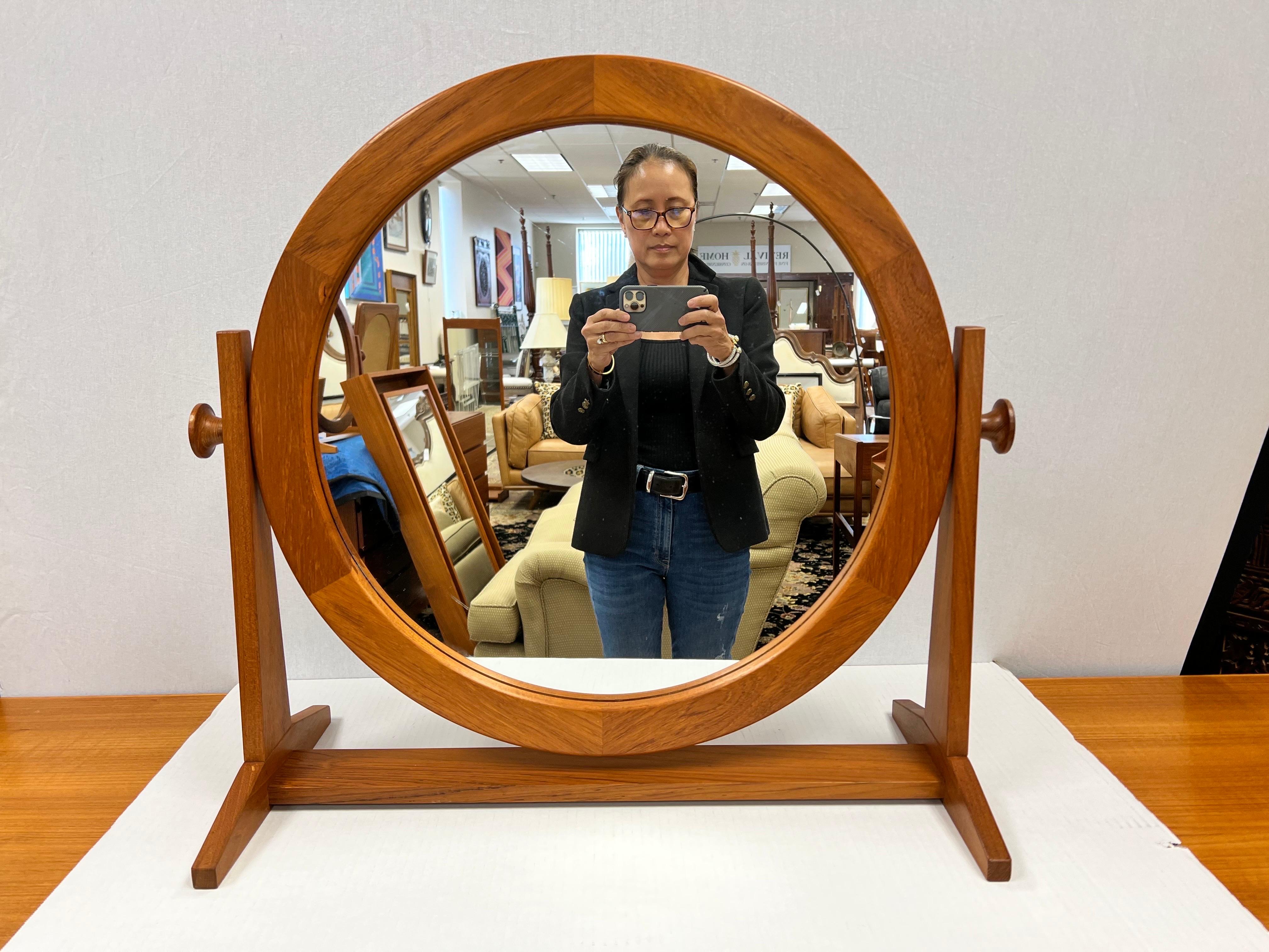 Iconic Large table top cheval mirror by Pedersen & Hansen. The glass portion is 19.5 inches in diameter and the frame with the knobs is 28 inches wide. The frame is made of teak. The mirror frame has great finger joint details. The mirror can tilt