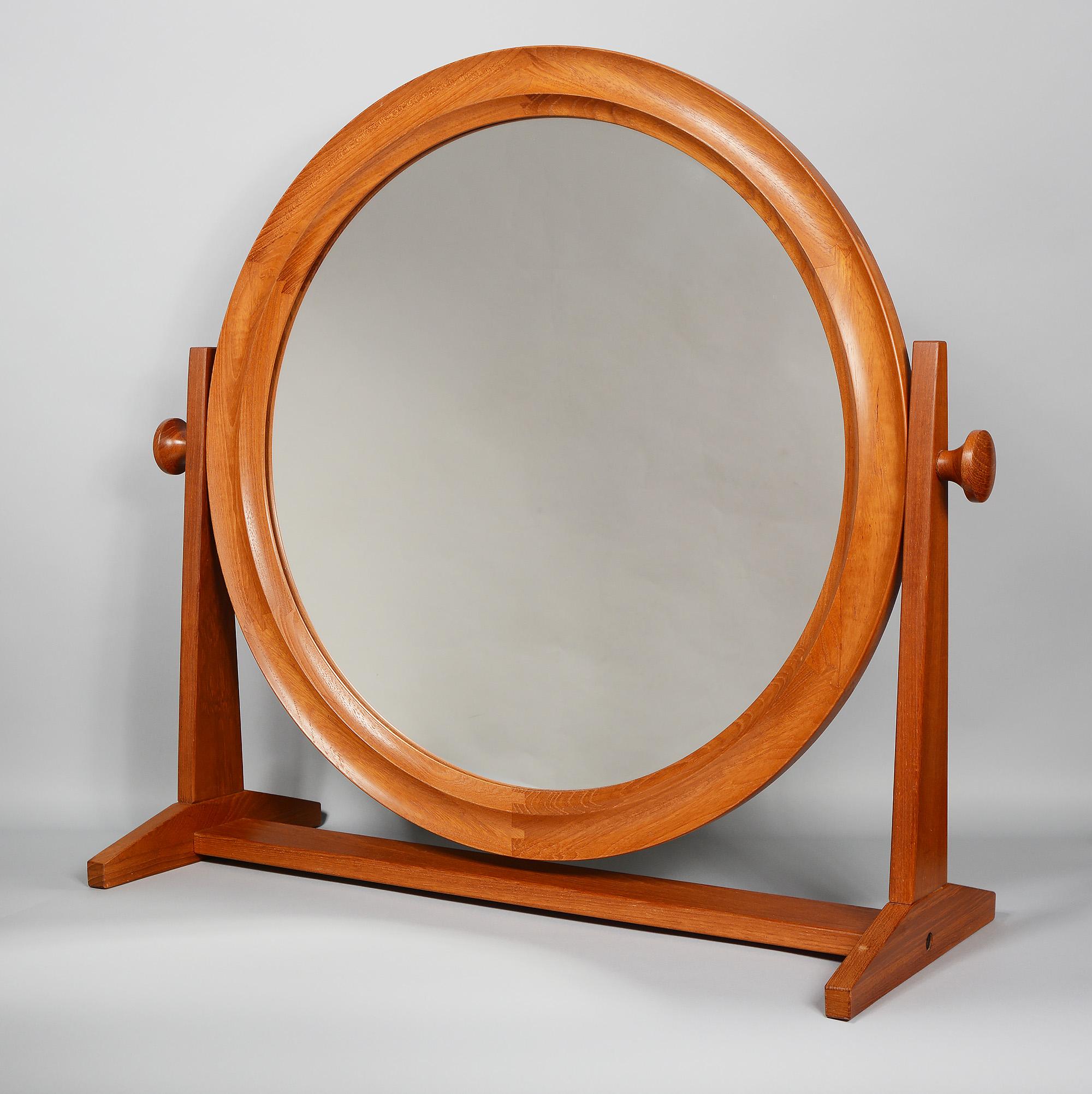 Large table top cheval mirror by Pedersen & Hansen. The glass portion is 19.5 inches in diameter and the frame with the knobs is 28 inches wide. The frame is made of teak. The mirror frame has great finger joint details. The mirror can tilt up or