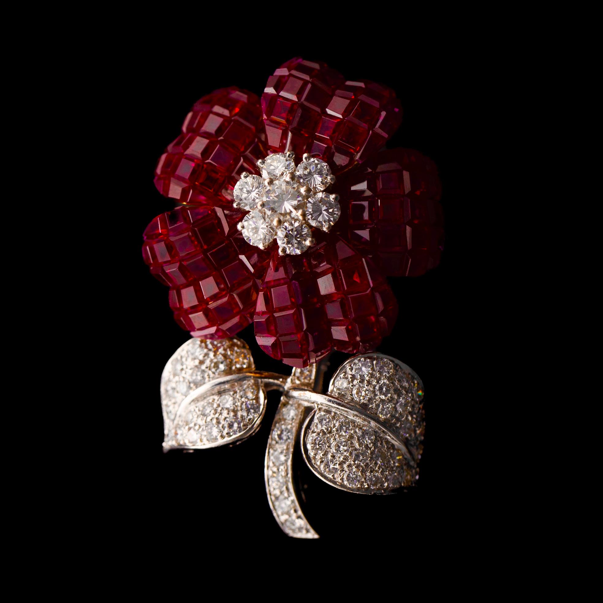 Pederzani invisibly-set ruby and diamond flower brooch in 18kt yellow and white gold, late 20th / early 21st century, Italy. Unravel the mysteries of the world’s most intricate gem setting technique – the invisible setting, pioneered by Van Cleef &