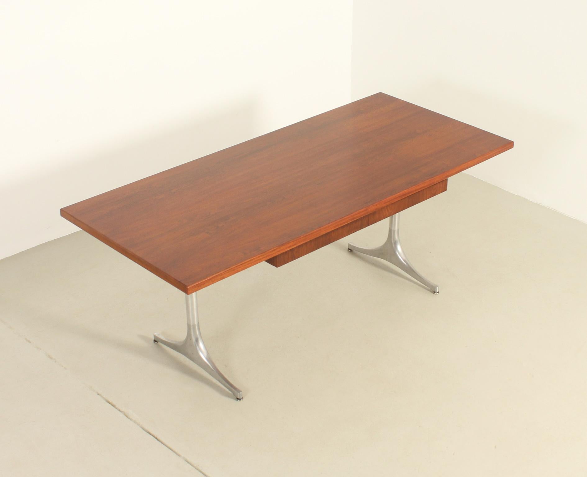 Scrivania con piedistallo progettata nel 1955 da George Nelson per Herman Miller, USA. Piano in legno di teak con due cassetti sottostanti e basi in alluminio lucido. 