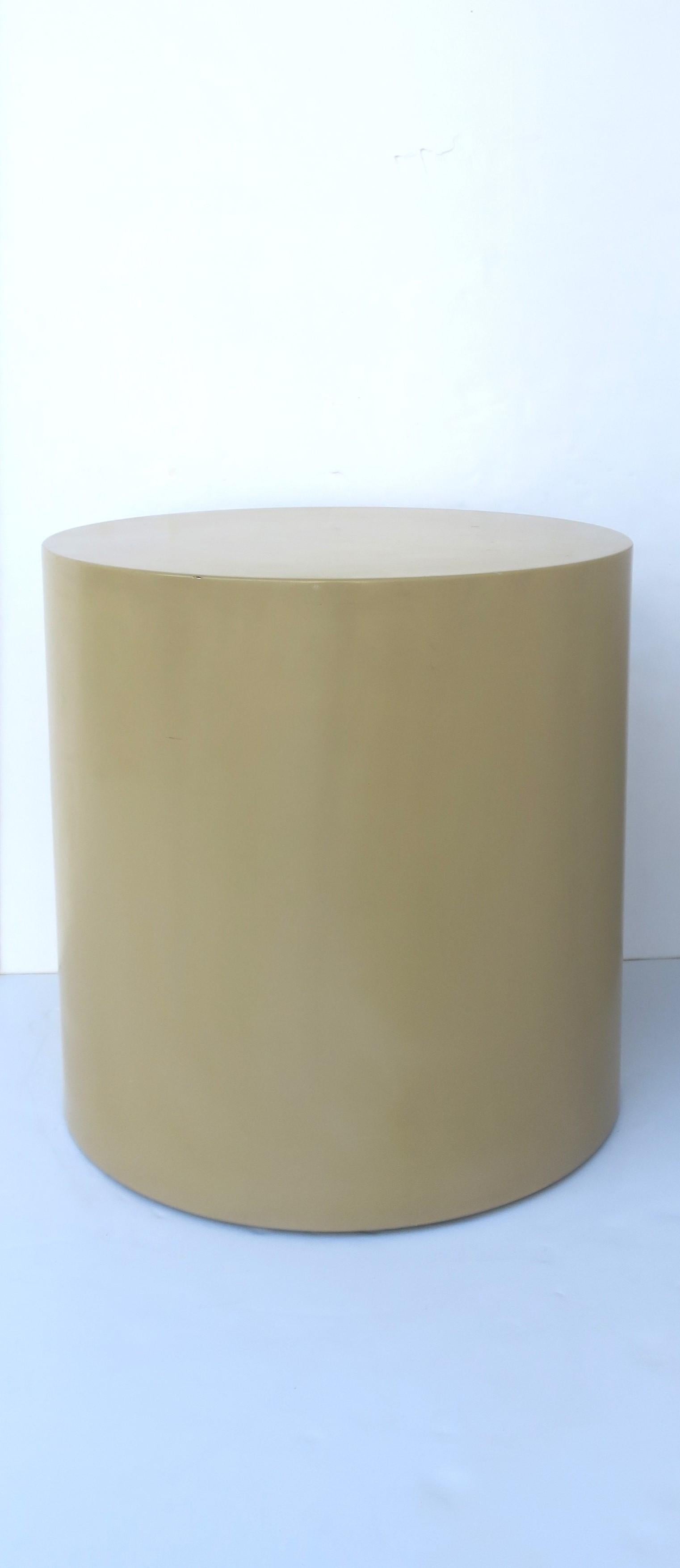 A round pedestal drum drinks, side, or end table in the Modern style, attributed to designer Paul Mayen for Habitat International furniture, circa late-20th century. Table is a neutral tan enamel hue. A great piece for many interiors with its