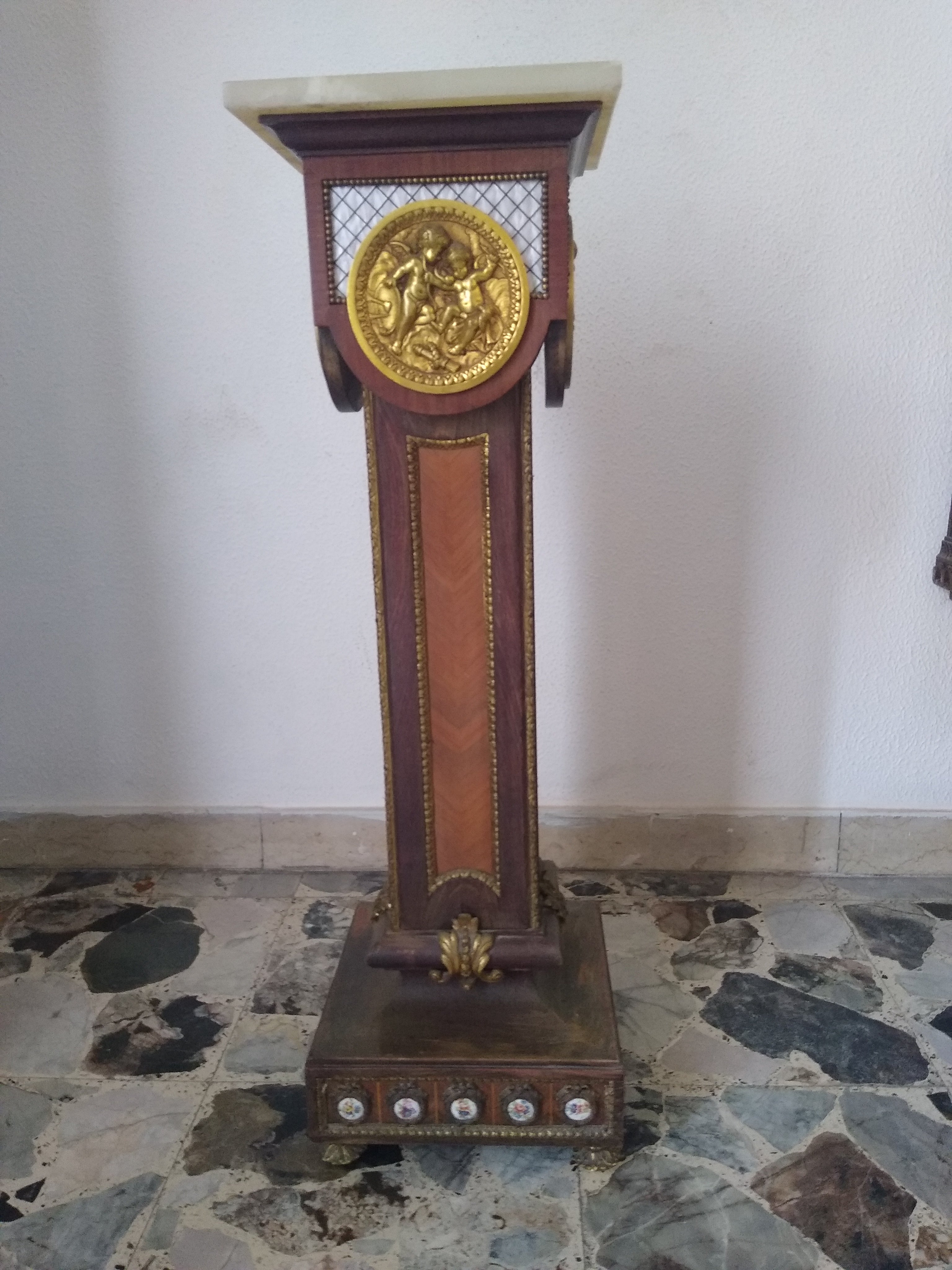 1940s Italian pedestal empire style in walnut with alabaster top and  bronze medallion depicting two putti  on each façade 
at the base porcelain plaques, bronze feet and bronze detailing throughout.
In good vintage condition with its original