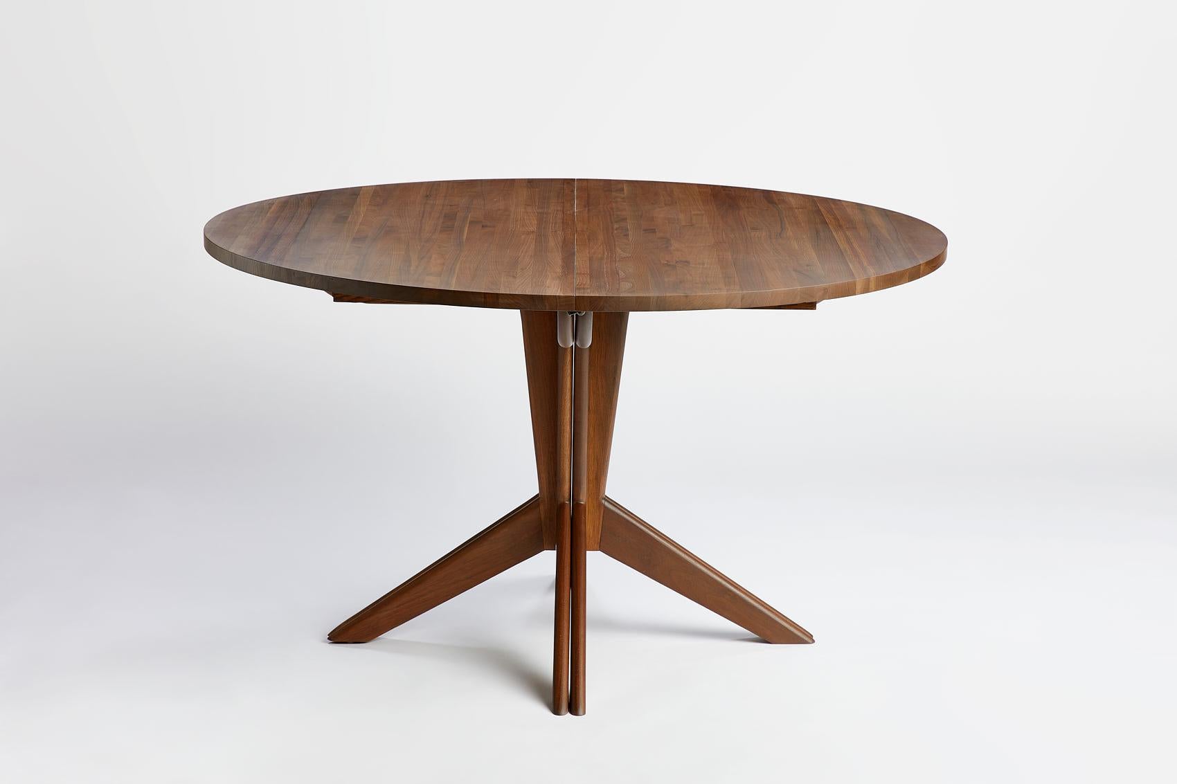 Designed by Mel Smilow in 1956, this completely restored vintage solid walnut extension dining table with a pedestal base is beautifully versatile. The simplicity of the table’s base splits and expands to accommodate 1-3 leaves. The table's solid