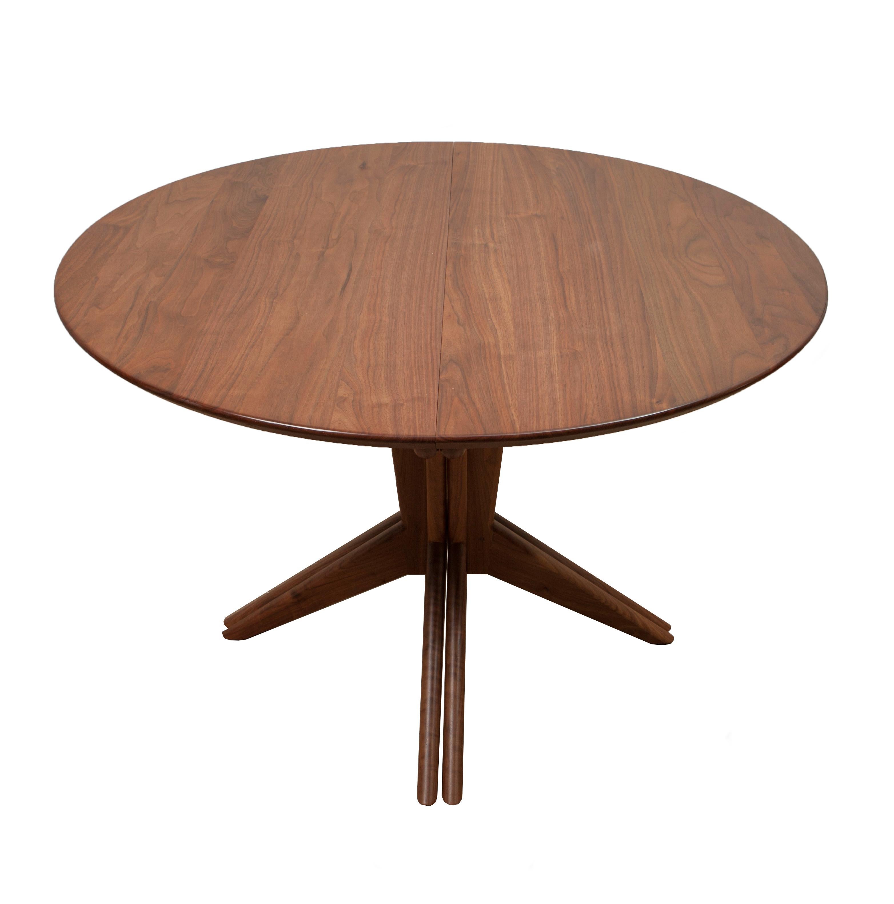 Originally designed by Mel Smilow in 1956 and officially reintroduced in 2014, this solid walnut extension dining table with pedestal base is beautifully versatile. The simplicity of the table’s base splits and expands to accommodate 1-3 leaves. The