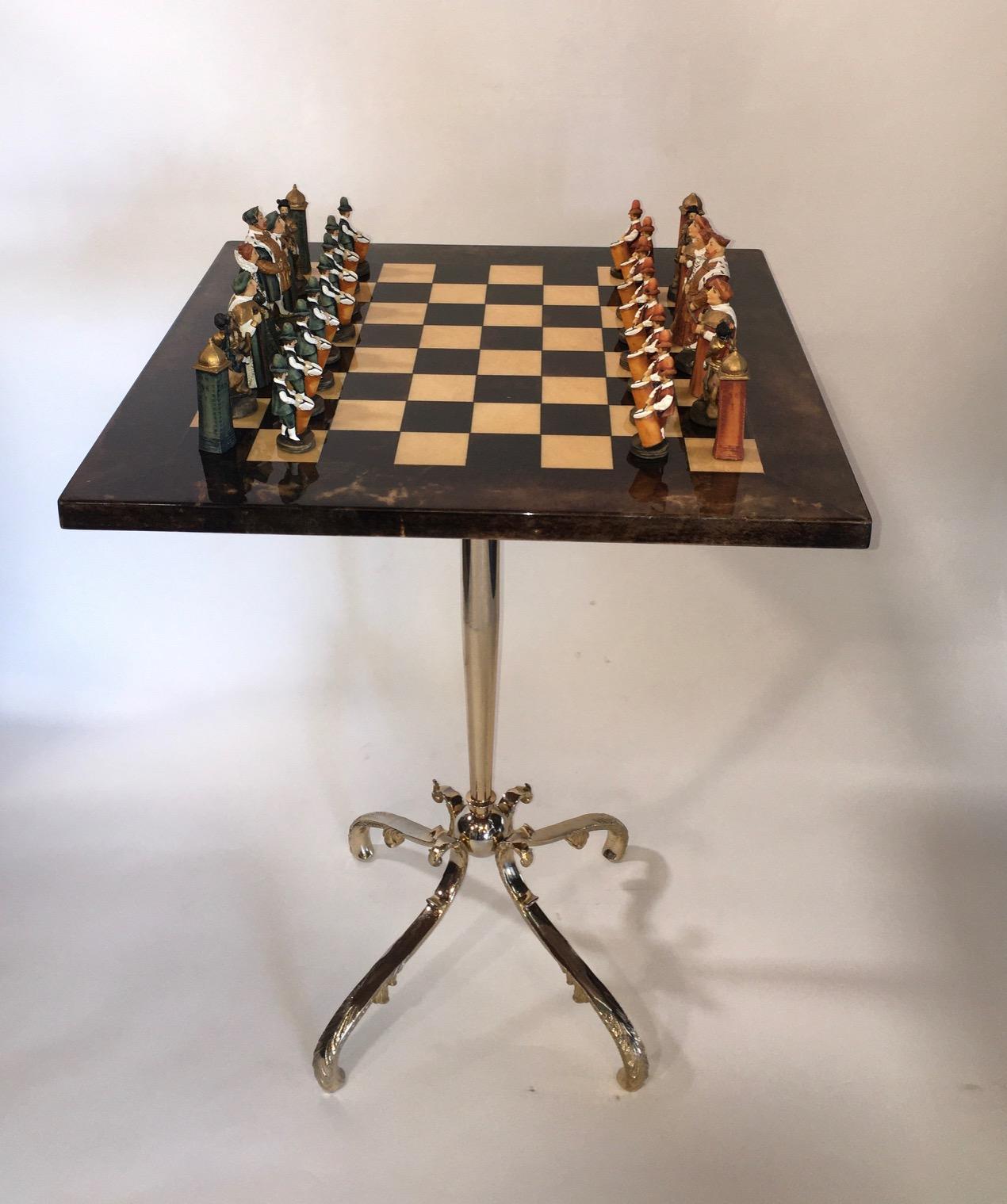 Pedestal parchment game table by Aldo Tura.
Chess pieces come included with the table.