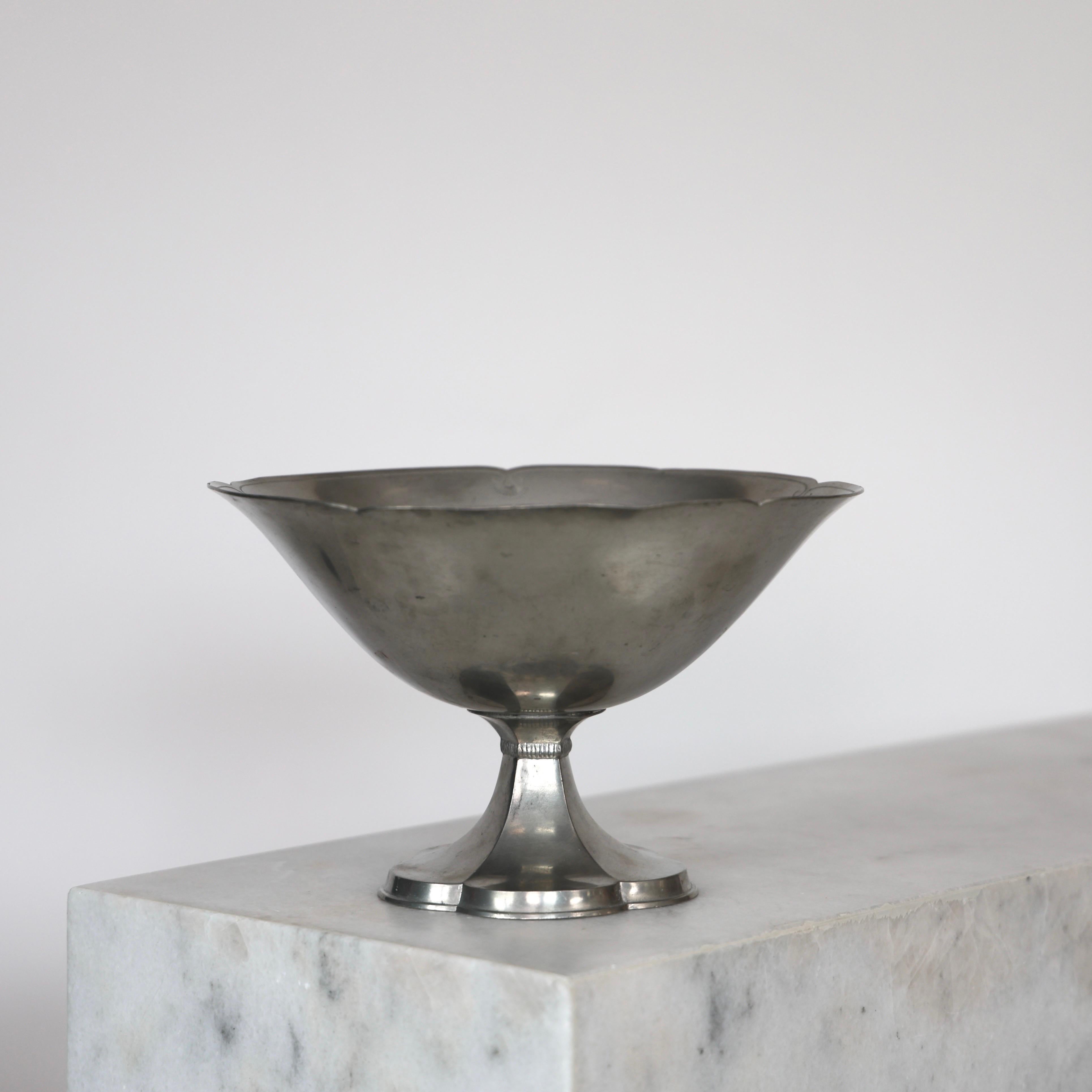 Pedestal Pewter Bowl designed by Just Andersen in the 1920s. A fine piece for a beautiful table.

* Pedestal pewter bowl on flower shaped foot.
* Designer: Just Andersen
* Style: 1194
* Year: 1918-1929
* Condition: Good vintage condition. Makers