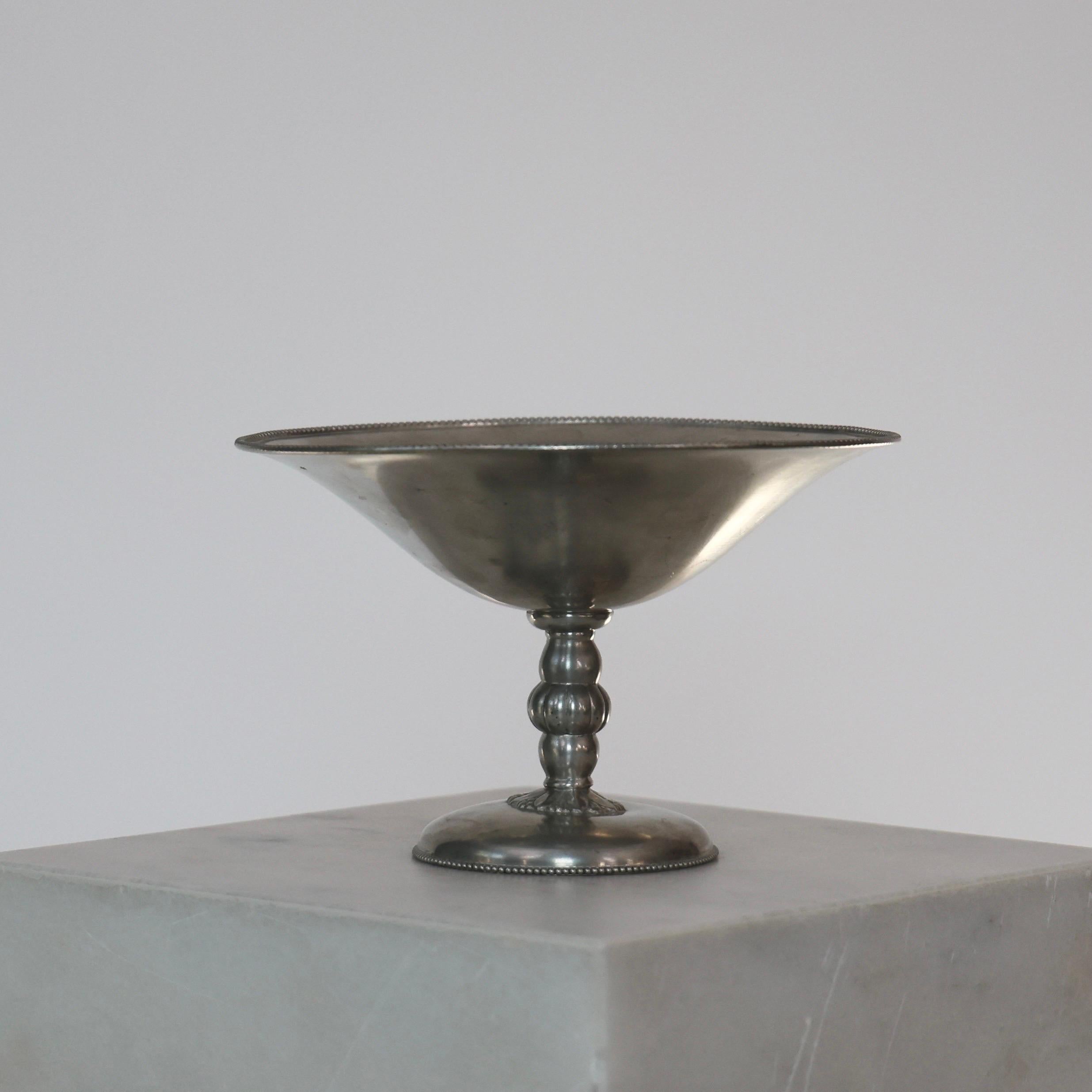 Pedestal Pewter Bowl designed by Just Andersen in the 1920s. A truly elegant piece.

* Pedestal pewter bowl on foot with delicate embossings.
* Designer: Just Andersen
* Style: 813
* Year: 1918-1929
* Condition: Good vintage condition. Makers
