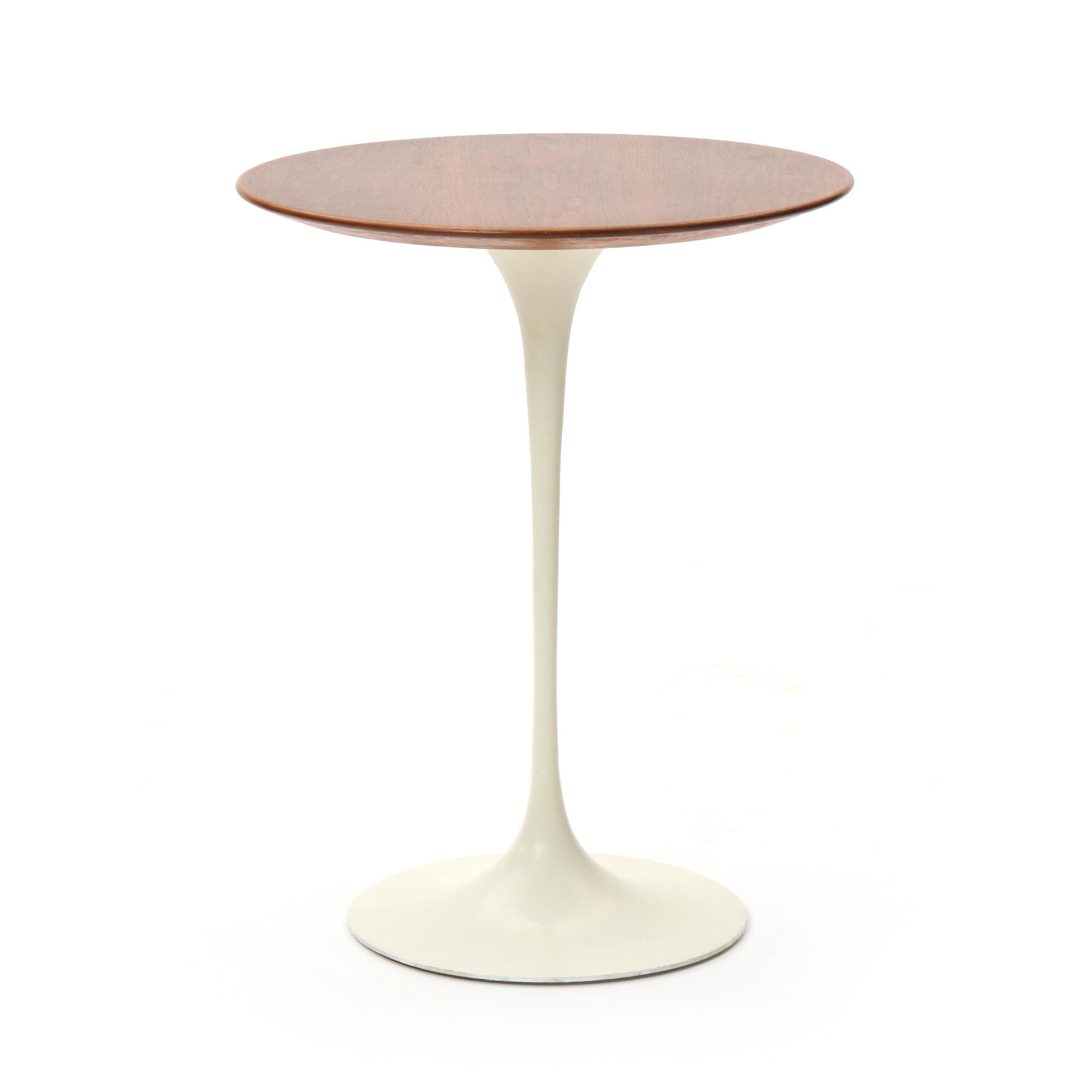 A circular end table with the original walnut veneer top and white cast iron pedestal base.