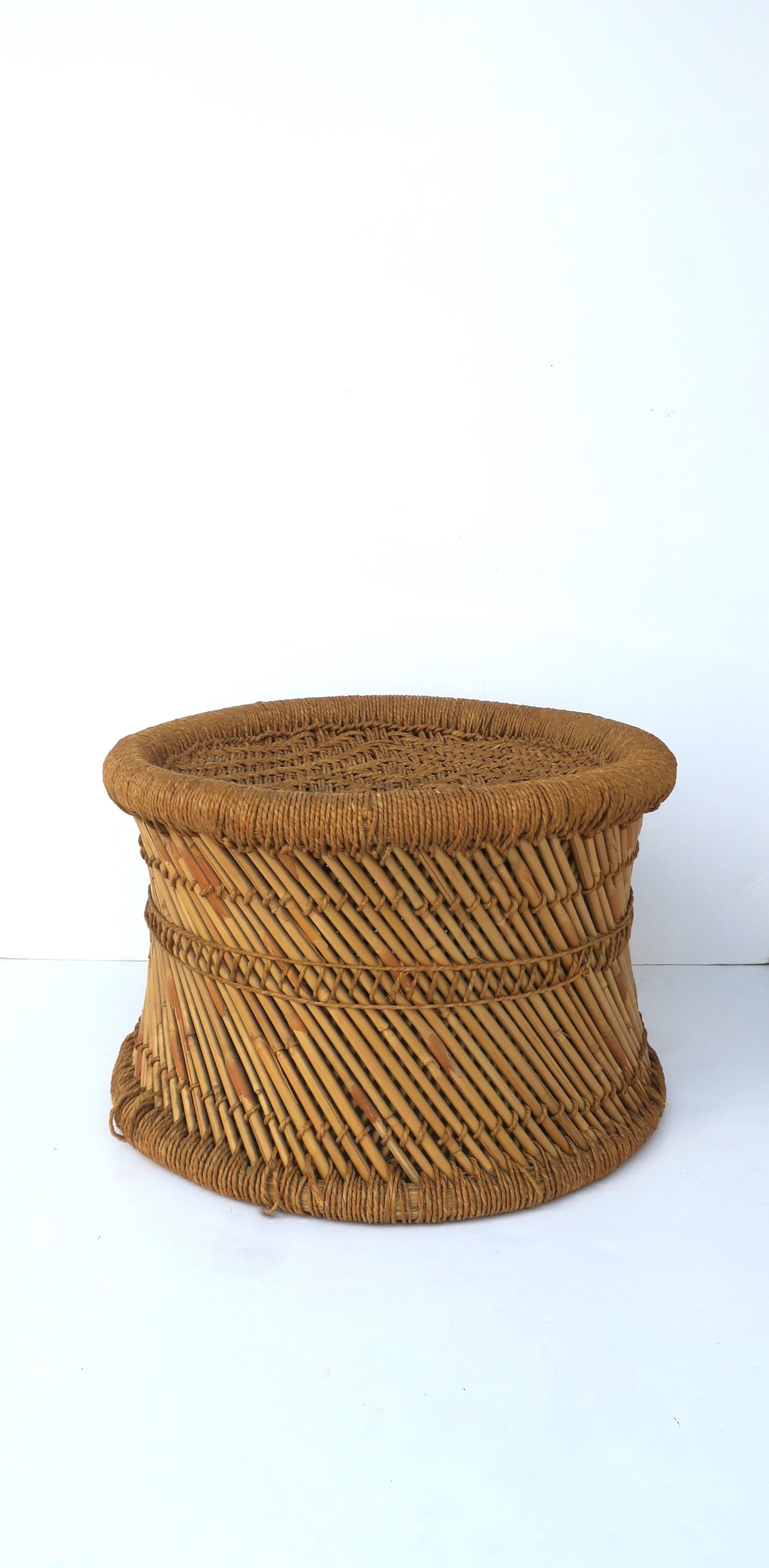 A vintage wicker pencil reed stool in the Anglo Raj style, circa mid-20th century, India. Stool is low, sturdy and well-made and can support a human being (as intended.) Stool can also double as a piece to hold books (demonstrated), a cocktail