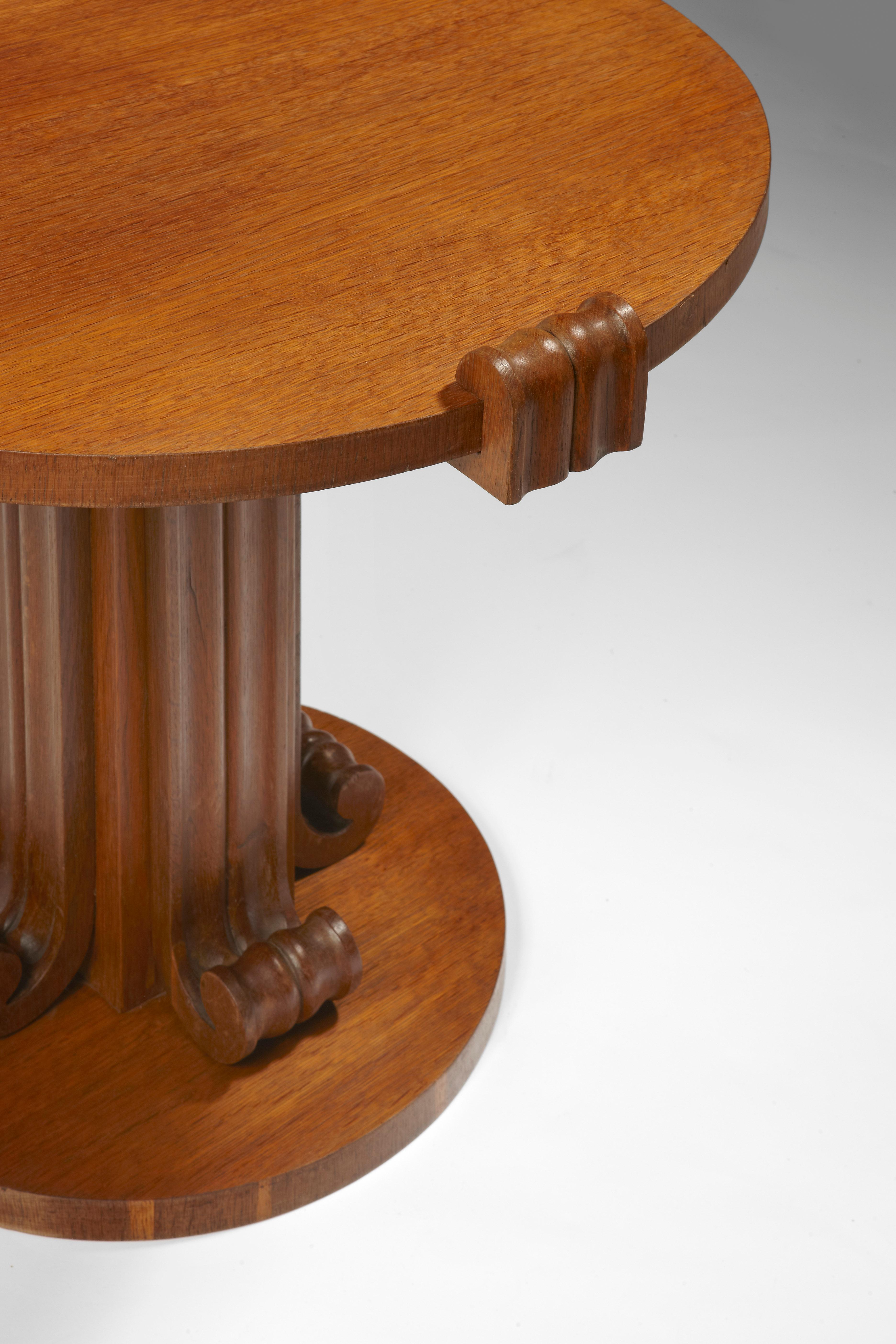 Mahogany pedestal table by Jean-Charles Moreux and Bolette Natanson, circa 1935-1936.
Pedestal table in mahogany tinted Oak. The circular top, maintained by four scrowls, stands on a central foot, ended with volutes. It stands on a circular