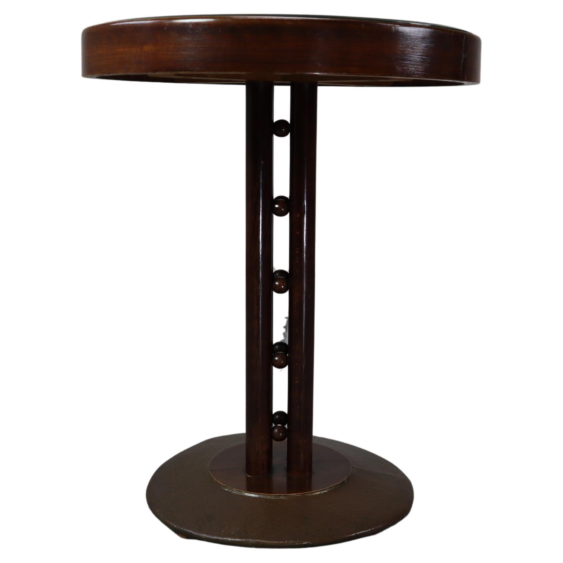 Mesa auxiliar Model No. 1262 diseñada por Josef Hoffmann en 1908 y ejecutada por J.& J. Kohn.
Cinco x cuatro bolas conectan cada una de las cuatro columnas.
Haya curvada y contrachapado, placa de latón martillado, tapa de cristal con textil original
