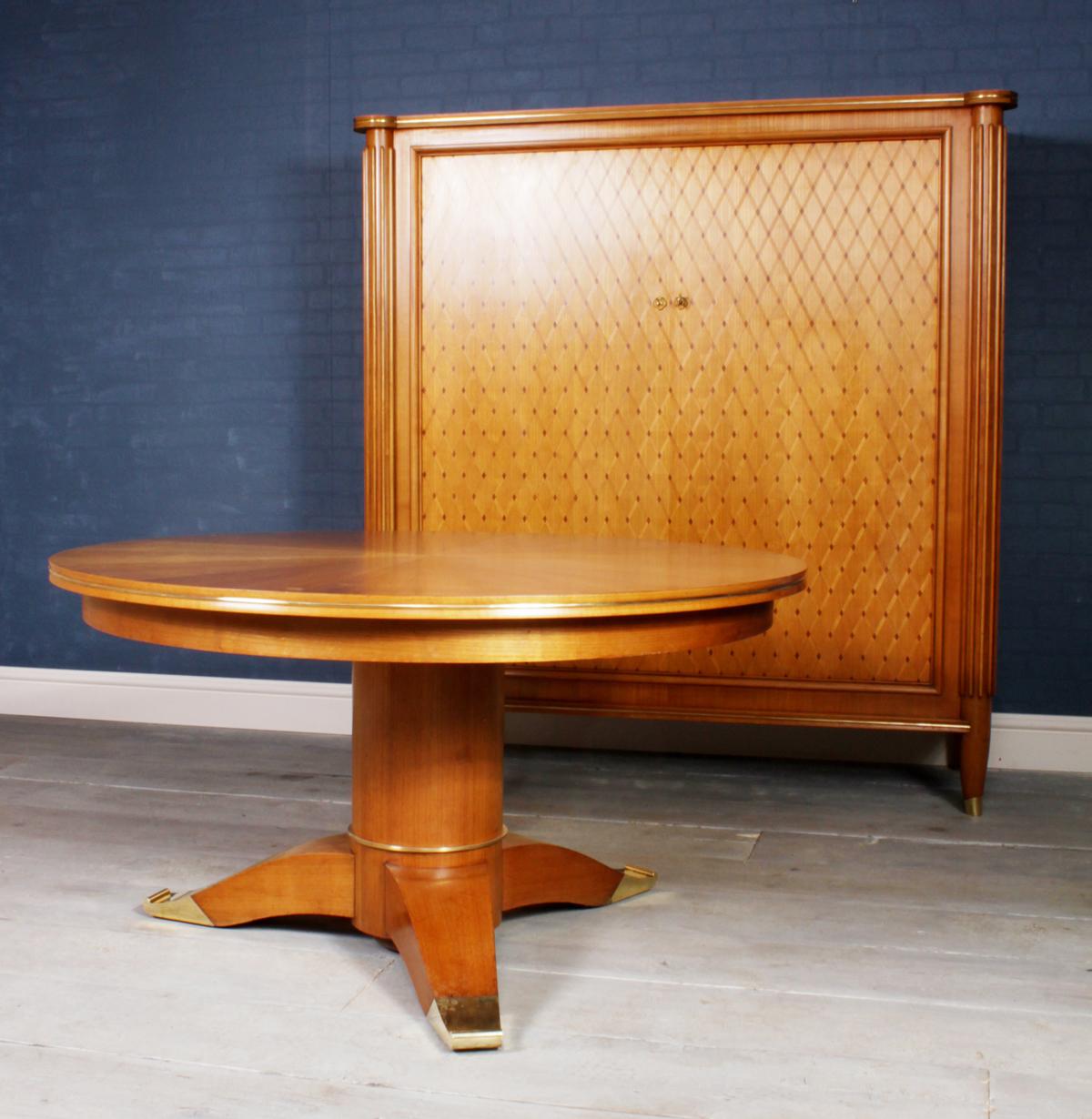 Pedestal table by Jules Leleu
A cherrywood segmented veneered pedestal table with polished bronze feet and trim produced by jules Leleu in 1956, model No. 28423 this table has a rising center so it can serve as a coffee table or a dining table,