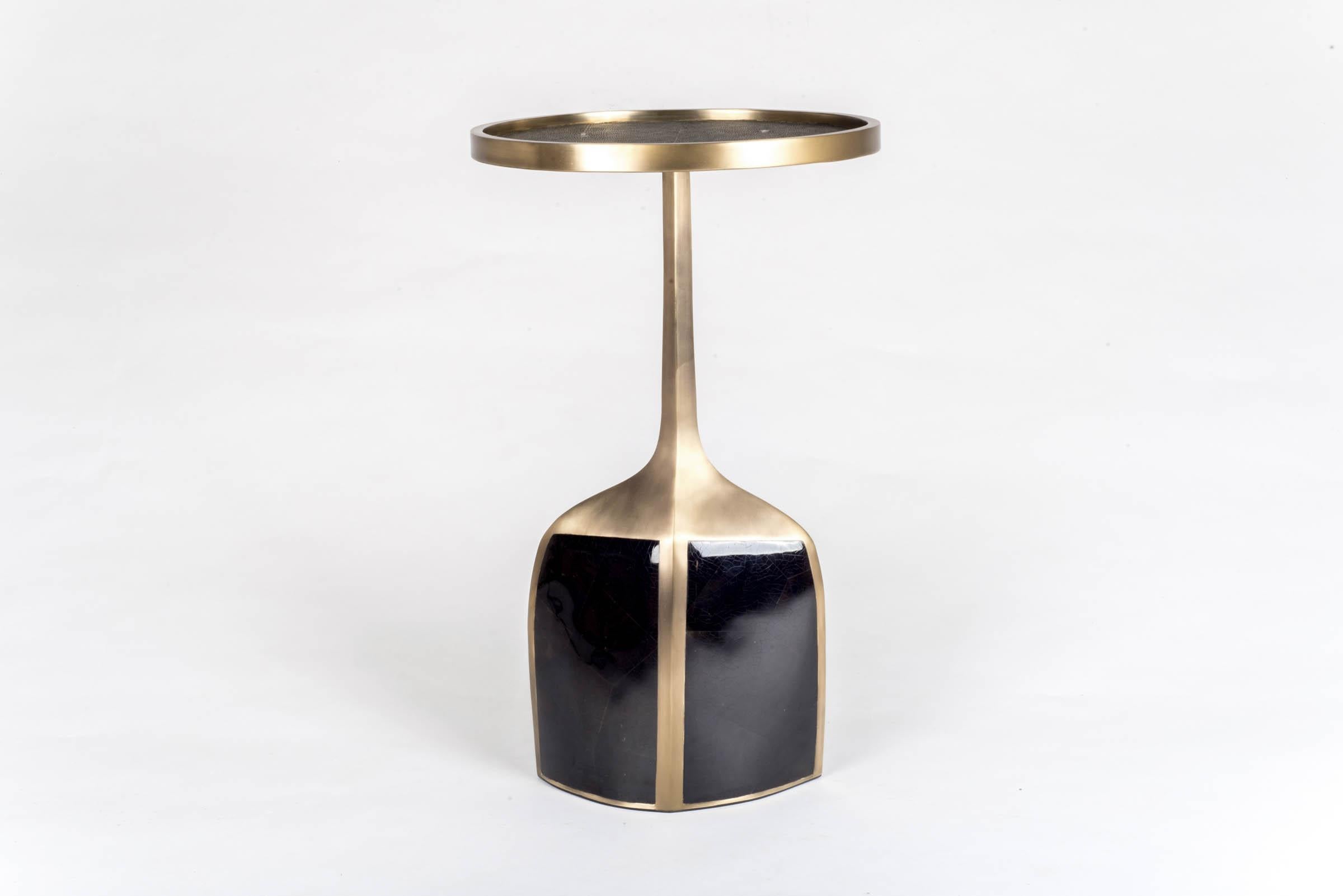 The pedestal side table large is the perfect accent piece due to it's sleek and light aesthetic. The large size is inlaid on the top surface with coal black shagreen, the bottom part a mixture of black pen shell and bronze patina brass. A small size