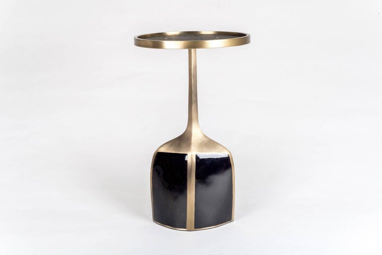 The pedestal side table large is the perfect accent piece due to it's sleek and light aesthetic. The large size is inlaid on the top surface with black shagreen, the bottom part a mixture of black pen shell and bronze patina brass. A small size is