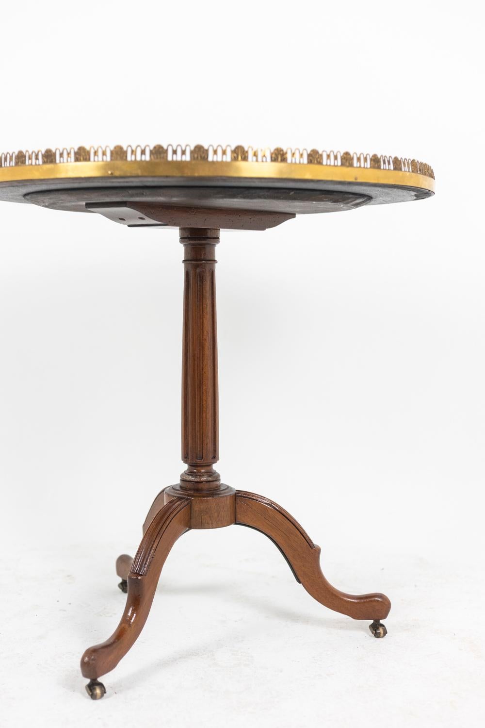 Pedestal table of Directoire style in mahogany, circular in shape. Top with white marble veined, openwork gallery in gilded bronze. Fluted foot. Tripod base standing on small wheels.

French work realized circa 1900.

Dimensions : H 72 x D 70