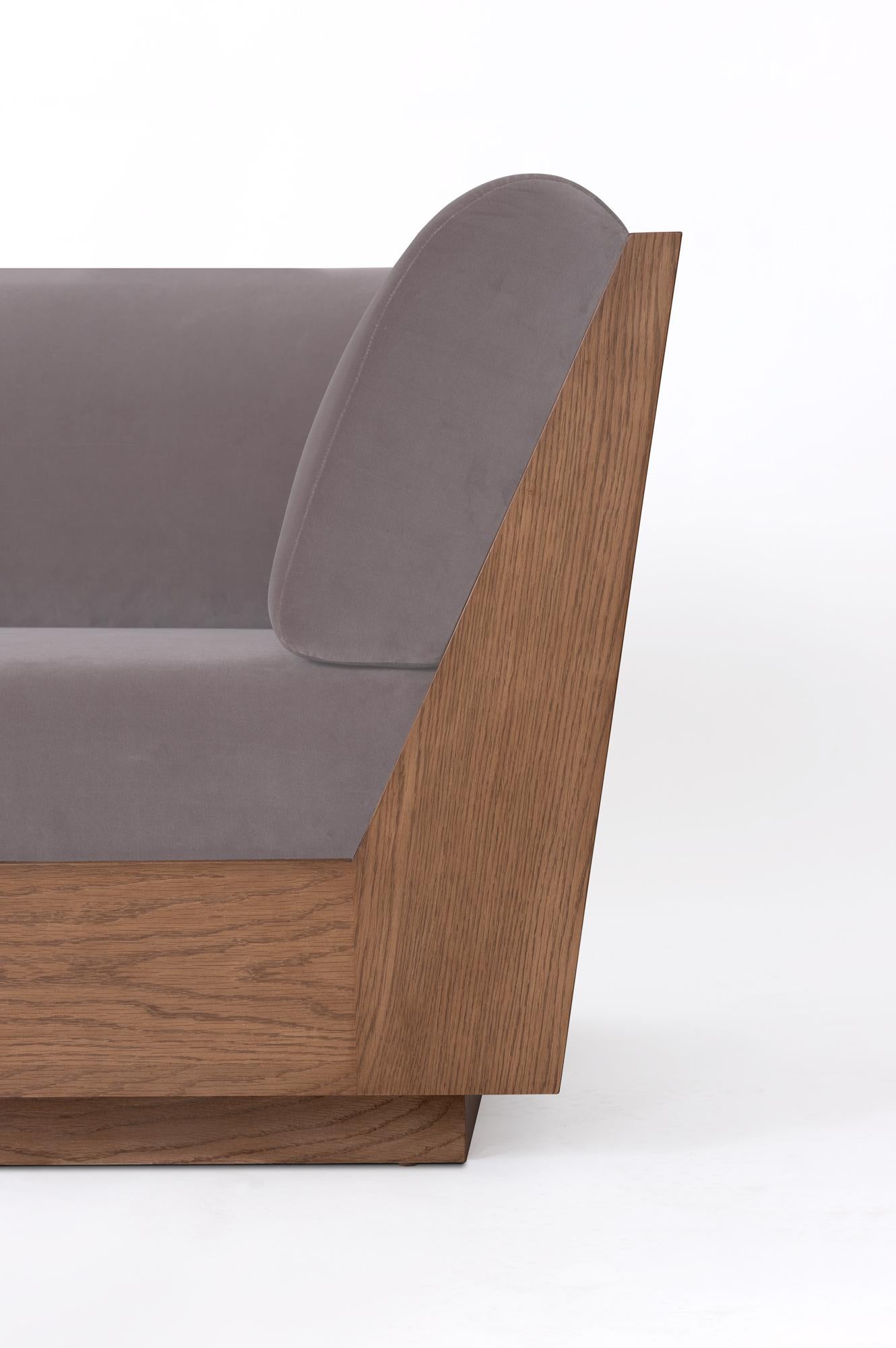 Das Sofa PEDREGAL zeichnet sich durch klare, minimalistische Linien und einen klaren Schnitt aus. Der Sockel und der Rahmen aus abgestuftem Eichenholz bilden ein markantes Profil, das die Strenge der Silhouette mit Wärme
