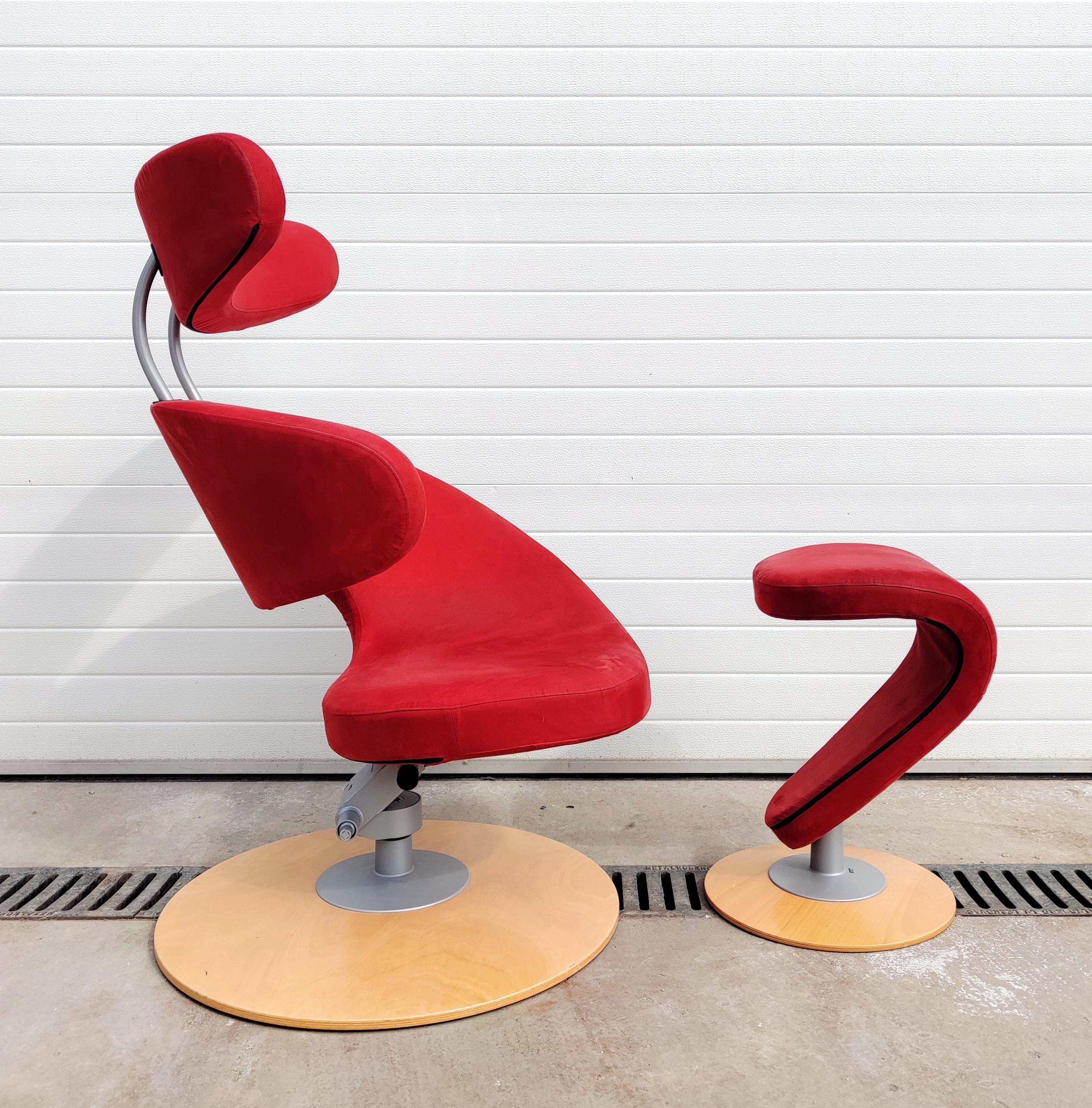 In this listing you will find a postmodernist armchair calledPeel Armchair with foot rest in red fabric. It was designed by Olav Eldoy and made in Norway in 2002. It features round wooden base and aluminum construction and comes together with a foot