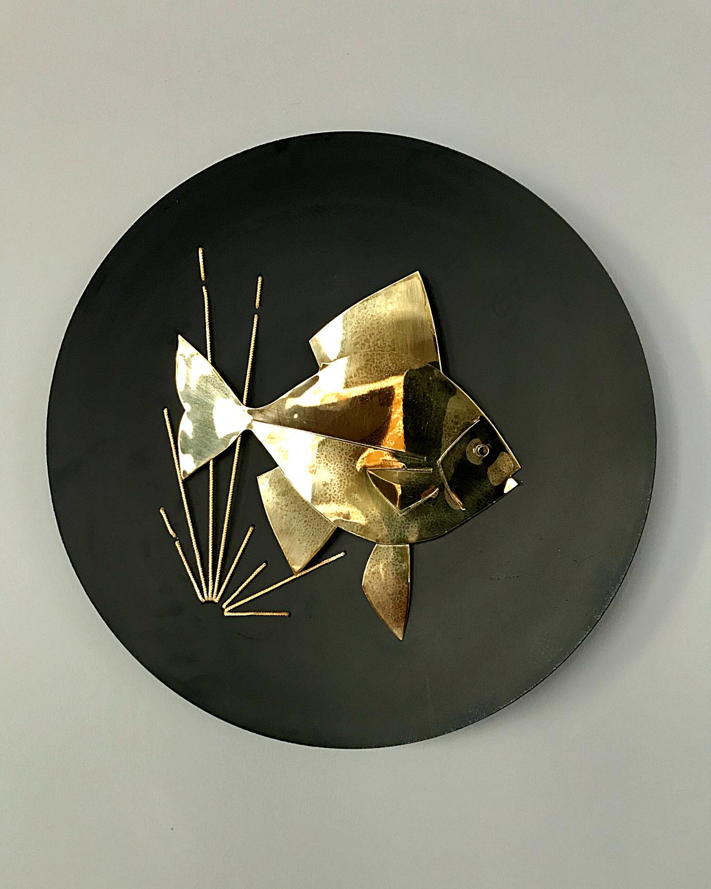 Very decorative modernist nautical motif wall plate. Handmade of black lacquered metal plate with brass fish from 1950s, by Peerage. In very good vintage condition.

   