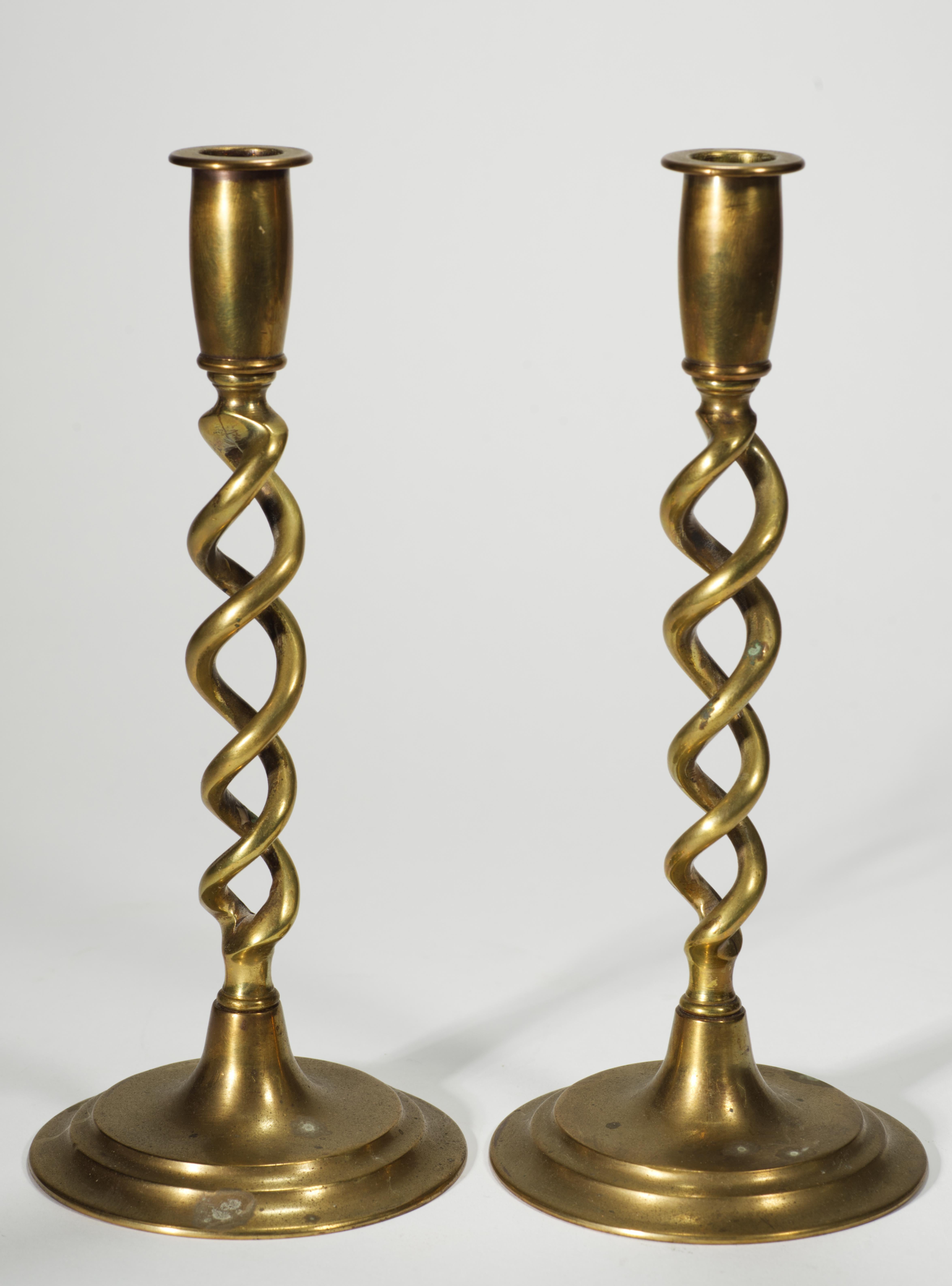  La coppia scultorea di portacandele in ottone antico presenta un design aperto a orzo e basi rotonde a gradini. Il design è una versione del XX secolo dello storico stile Revival Giacobino, molto popolare all'inizio del XX secolo.

I candelieri