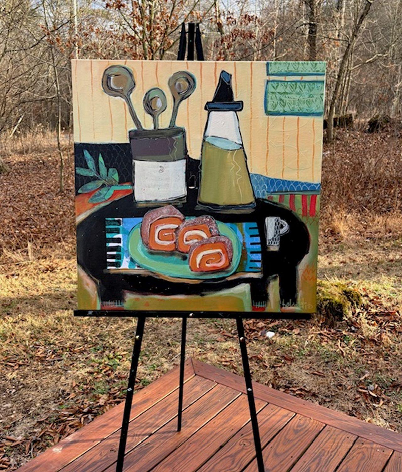 <p>Artist Comments<br />A tall vintage-style glass jug, a crock with three wooden spoons, and a plate of pumpkin rolls rest on a table. Artist Peg Belcastro created the fern leaves using handmade collaged gelli print paper. Bold colors, geometric