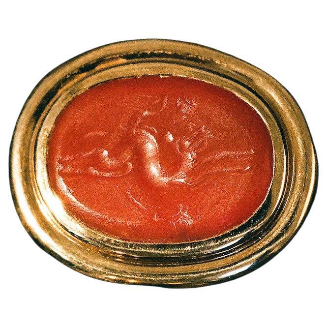A one-of-a-kind signet ring featuring an antique, intaglio-engraved carnelian stone framed in 18k recycled gold. At once refined and pleasingly weighty, the stone is detailed with the profile of a mysteriously amorphous, pegasus-like figure. The