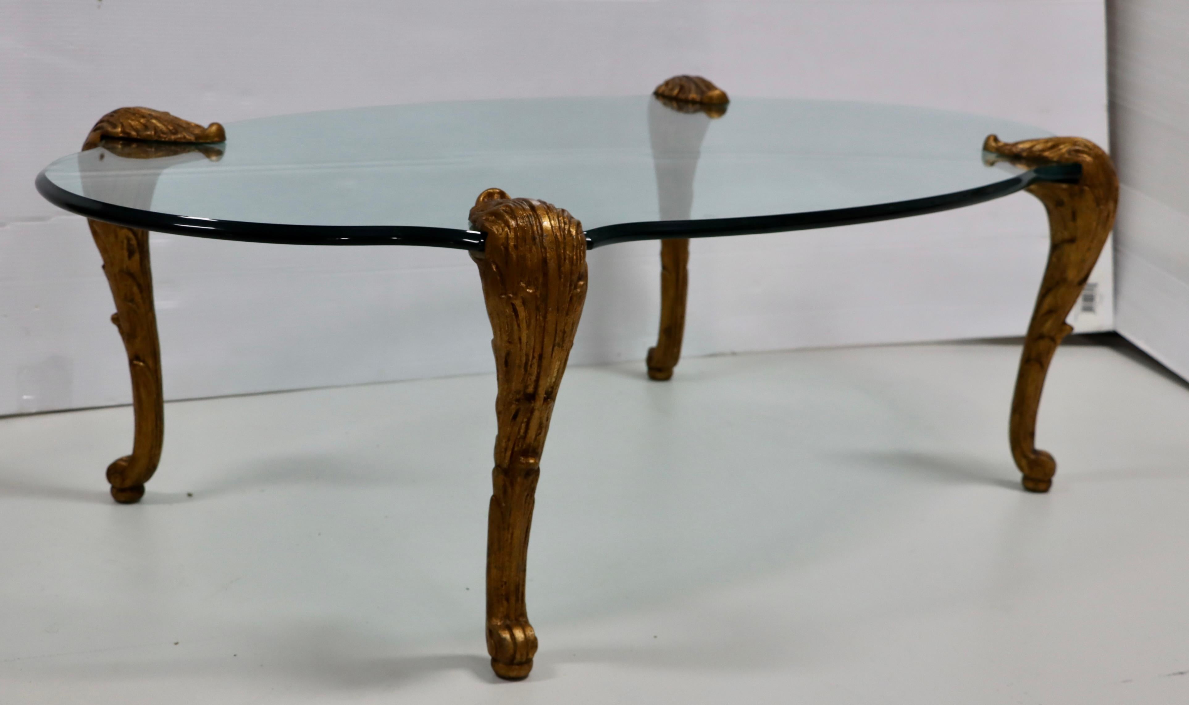 1960's modern solid cast iron gilded legs and glass coffee table in the style of P.E. Guerin with beveled thick glass, in vintage original condition with some wear and patina due to age and use, some light scratches to the glass, each legs weights
