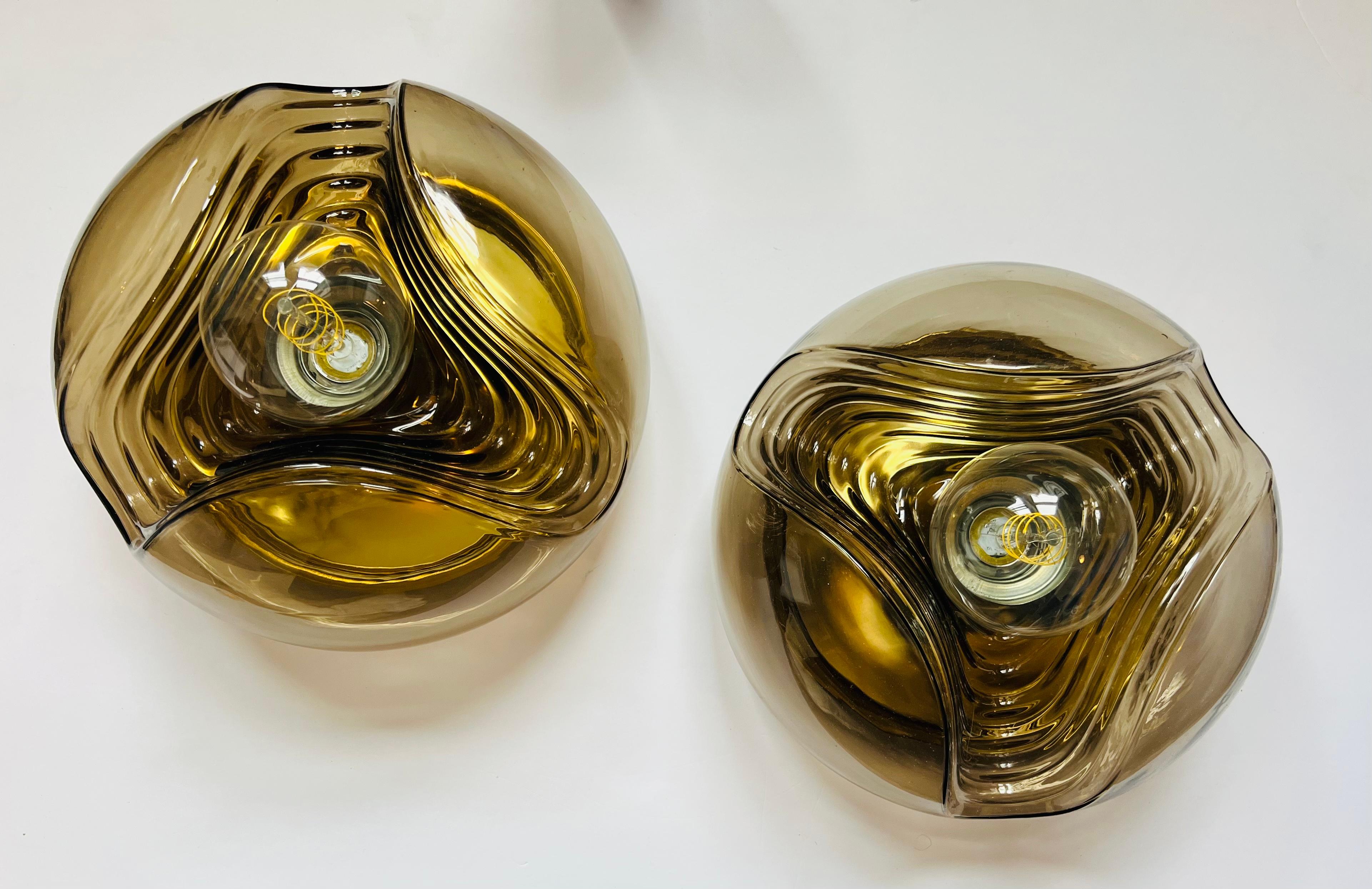 Una splendida coppia di lampade da soffitto o da parete con paralumi in vetro fumé a onda e cornici interne dorate di Peill & Putzler, C 1960 ricablata.