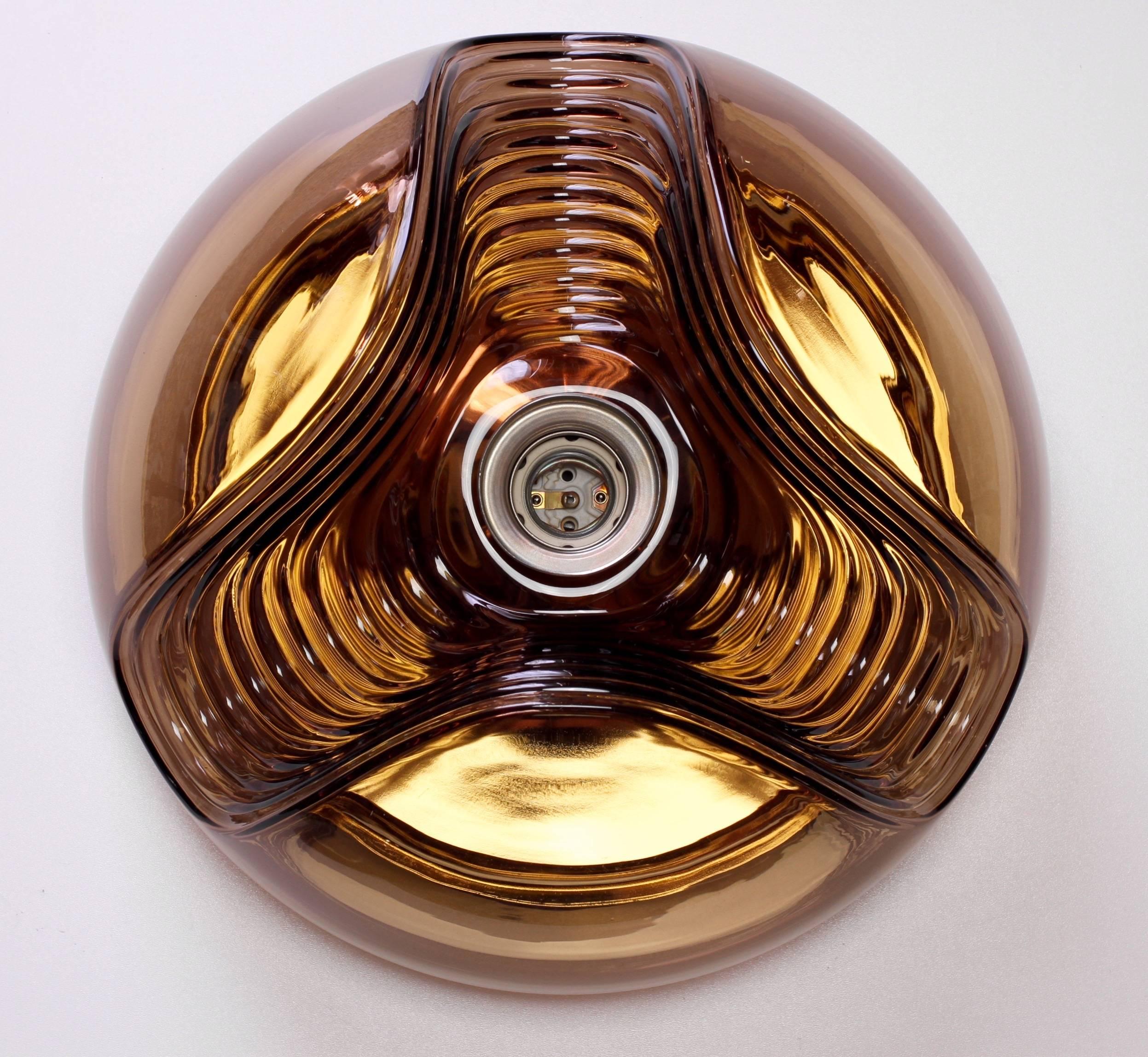 Midcentury pair of flush mount wall lights or sconces by Peill & Putzler in the 1970s. This is an absolutely classic piece of German design, featuring a smoked toned colored glass globe shade with a waved/ribbed molded bubble form, casting a