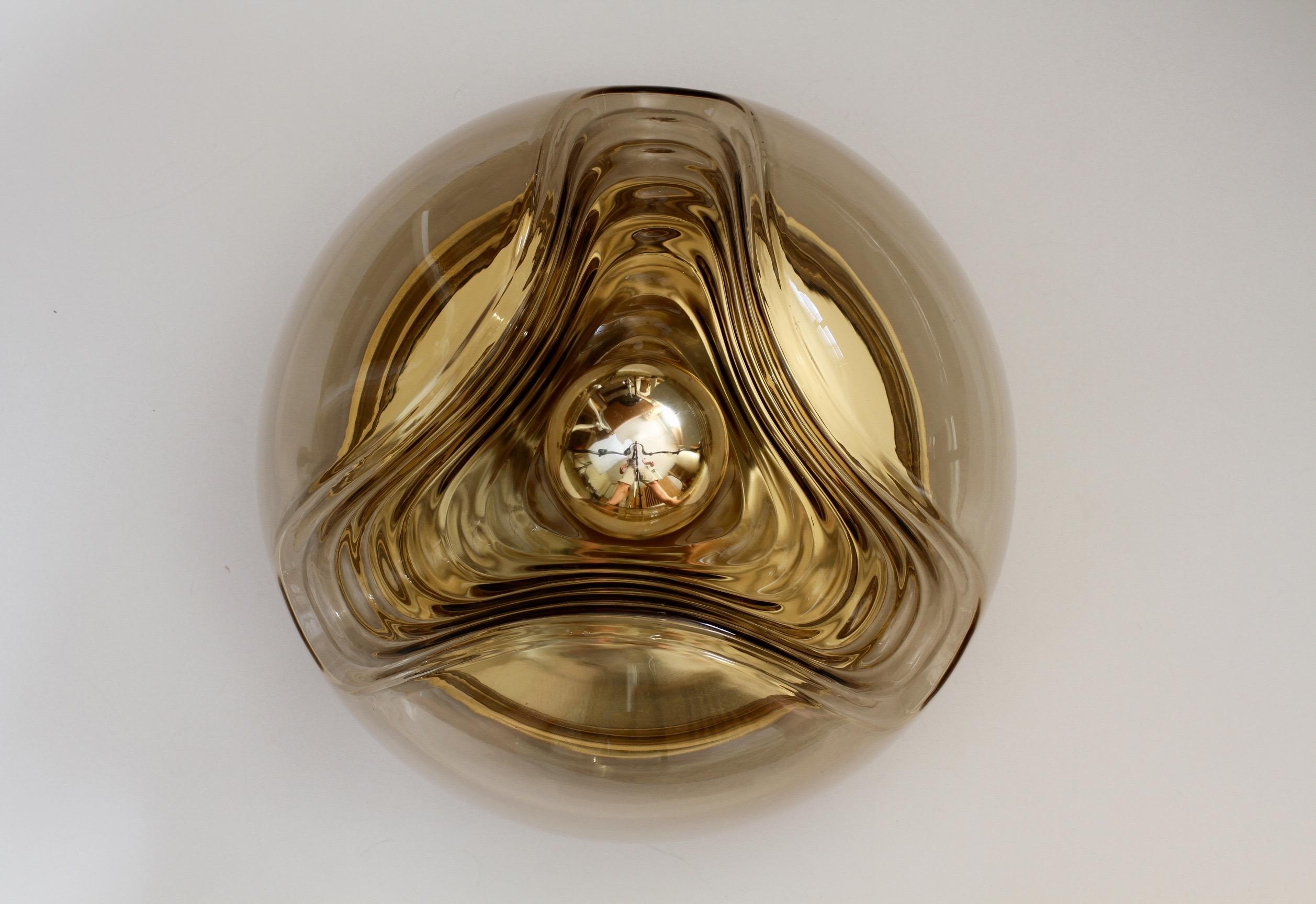 Midcentury pair of 32cm diameter flush mount wall lights or sconces by Peill & Putzler in the 1970s. This is an absolutely classic piece of German design, featuring a smoked toned colored glass globe shade with a waved/ribbed molded bubble form,