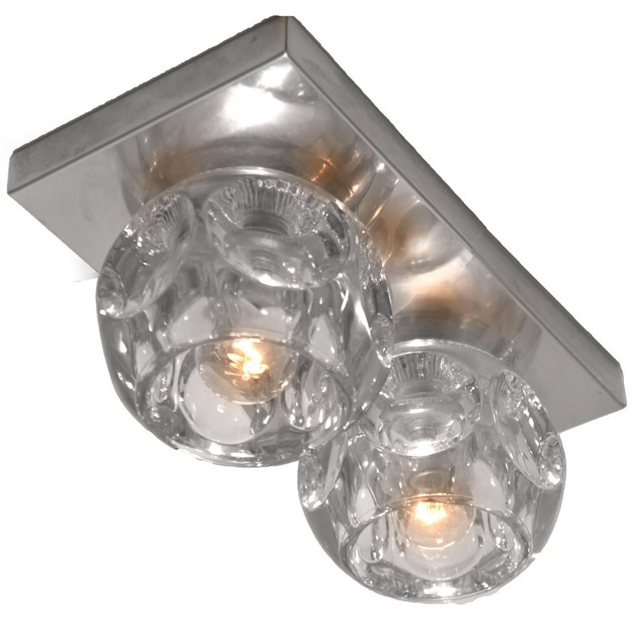 A beautiful set of Peill and Putzler light fixtures (wall or ceiling). Each sculptural light consists several clear glass cubes on a chrome frame which beautifully reflects the light with a warm glow. The quality thick clear glass shades have a
