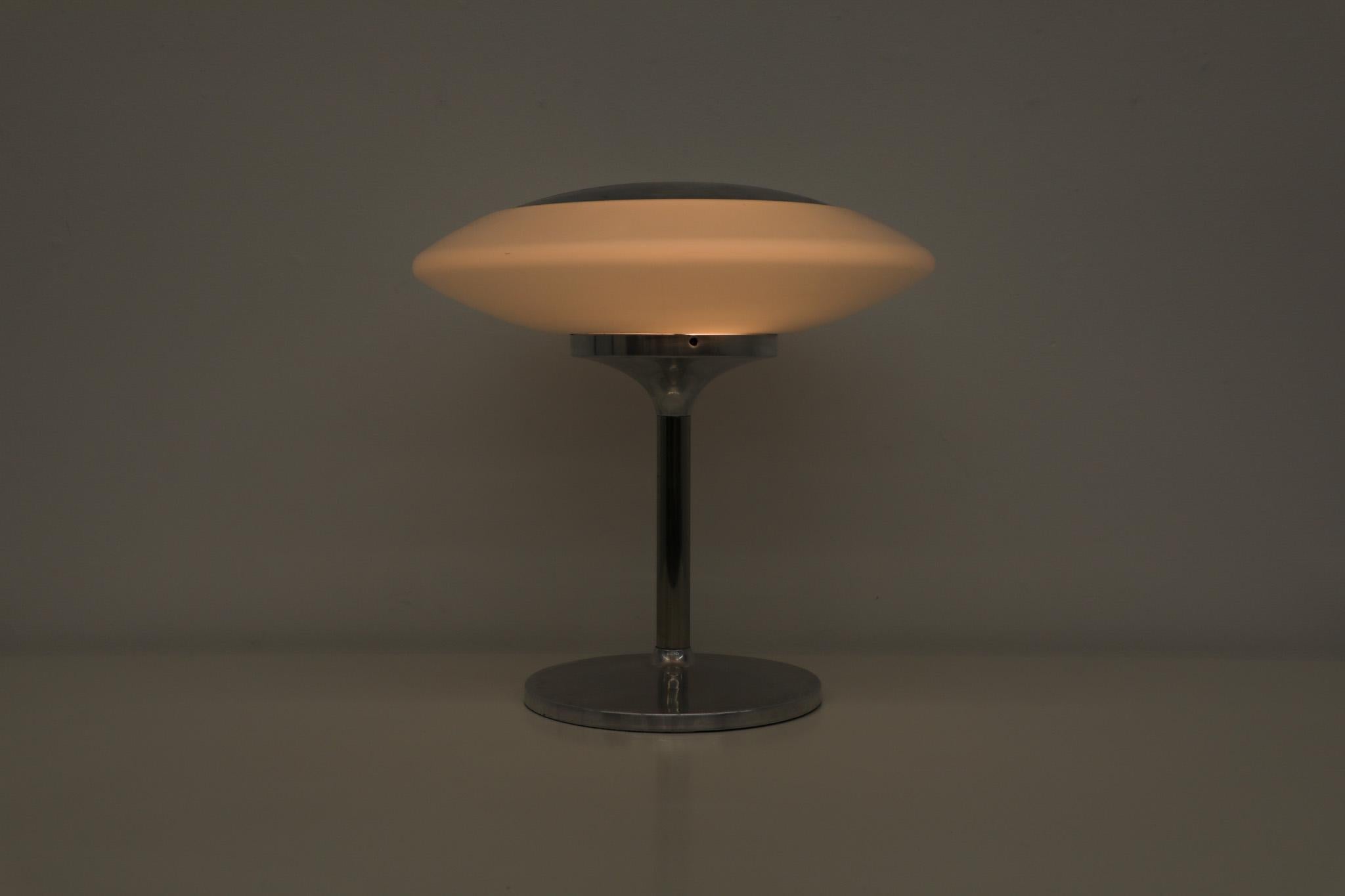 Stunning Peill & Putzler table lamp with milk glass shade and aluminum tulip base and an inset domed top plate. In original condition with wear and scratching consistent with its age and use. 