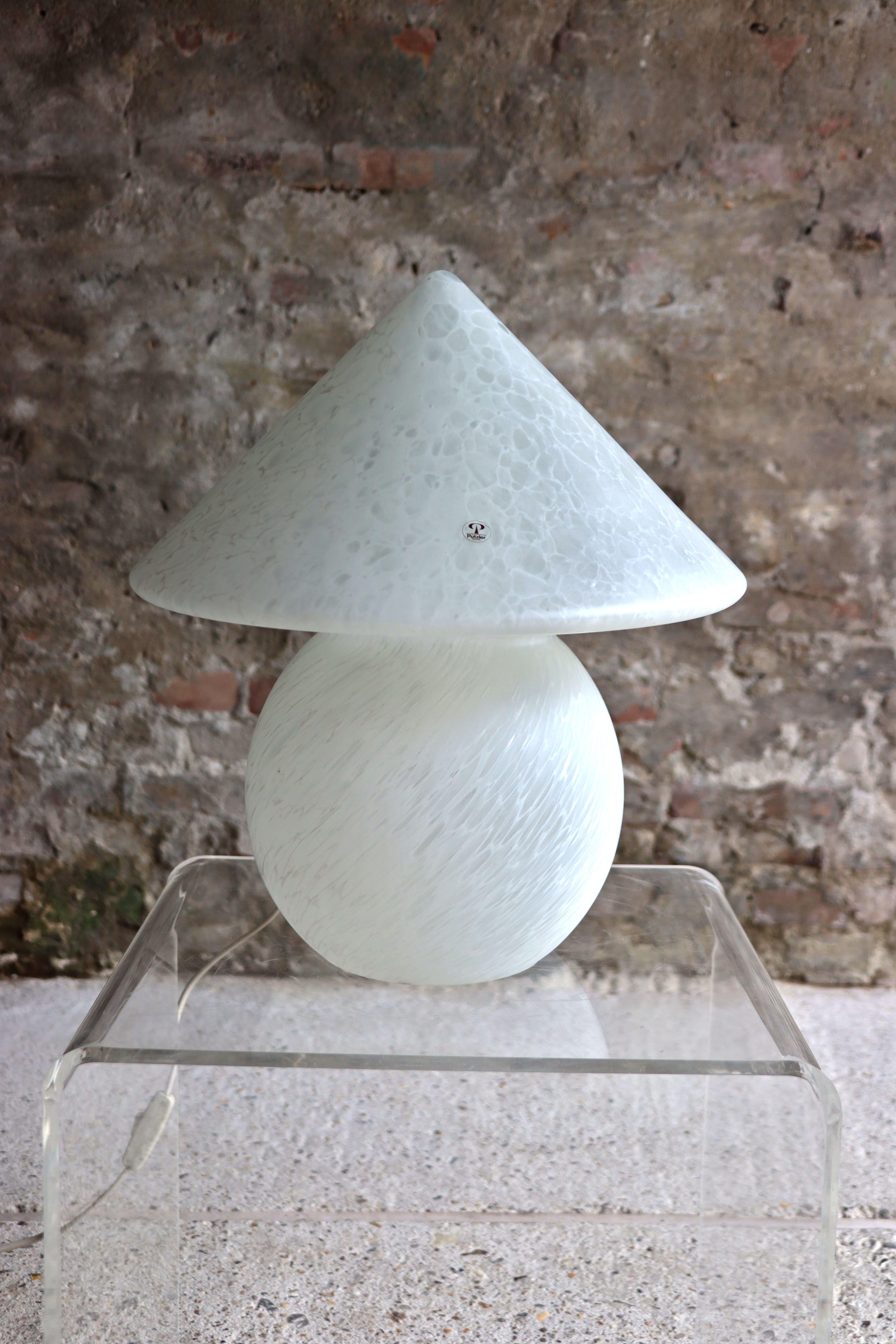 Cette lampe de table en forme de champignon a été conçue par Peill & Putzler dans les années 1970. Il est doté d'un magnifique verre opalin blanc et est en très bon état. Il présente un petit dommage sur la couche intérieure du verre. Il est presque