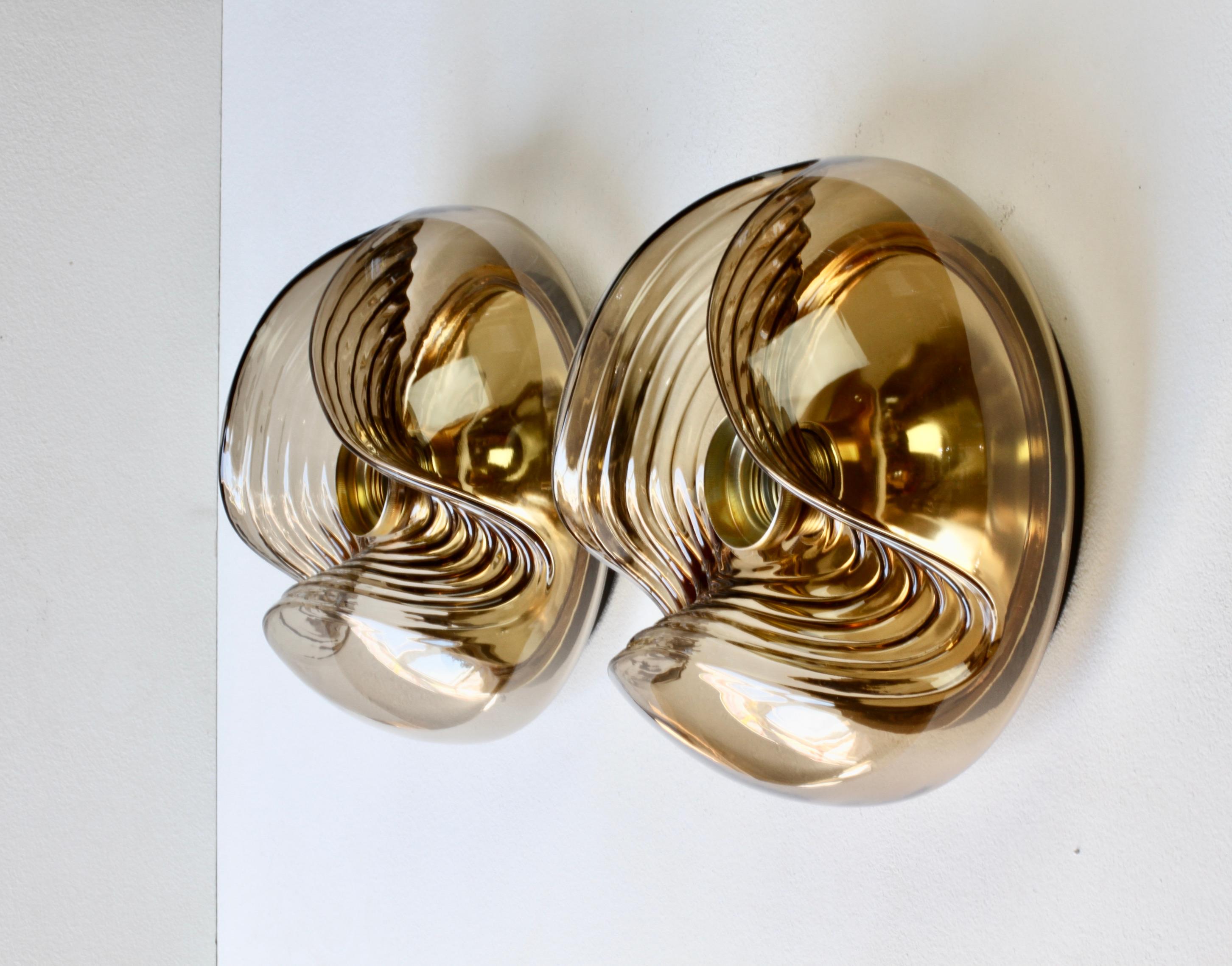 Pair of mid-century flush mount ceiling or wall lights / sconces by Peill & Putzler in the 1970s. This is an absolutely Classic piece of design, featuring a smoked coloured (colored) glass globe shade with a waved/ribbed molded bubble form, casting