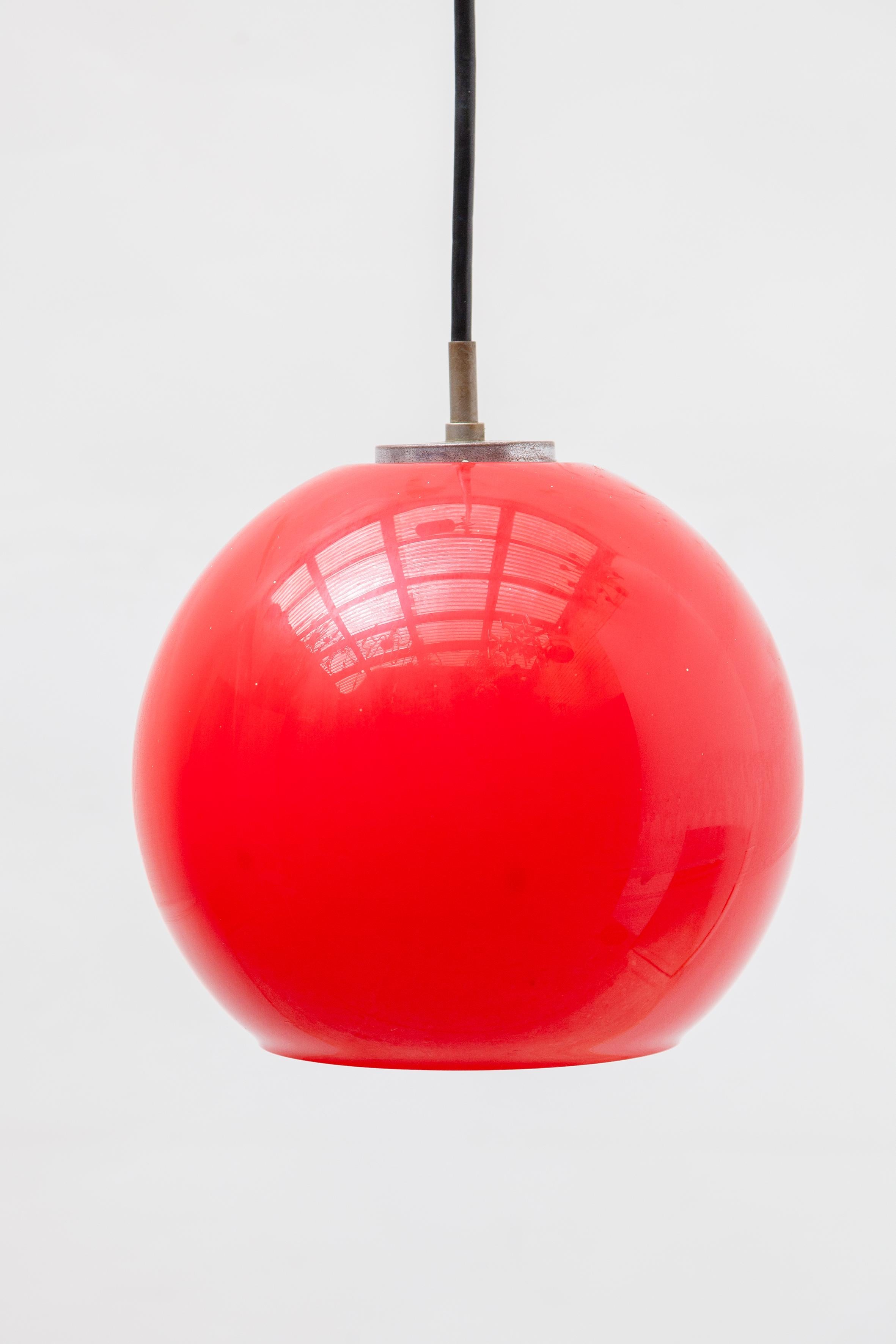 A modern deep red opal glass pendant designed by Koch and Lowy for Peill and Putzler, manufactured in Germany, circa 1950s.