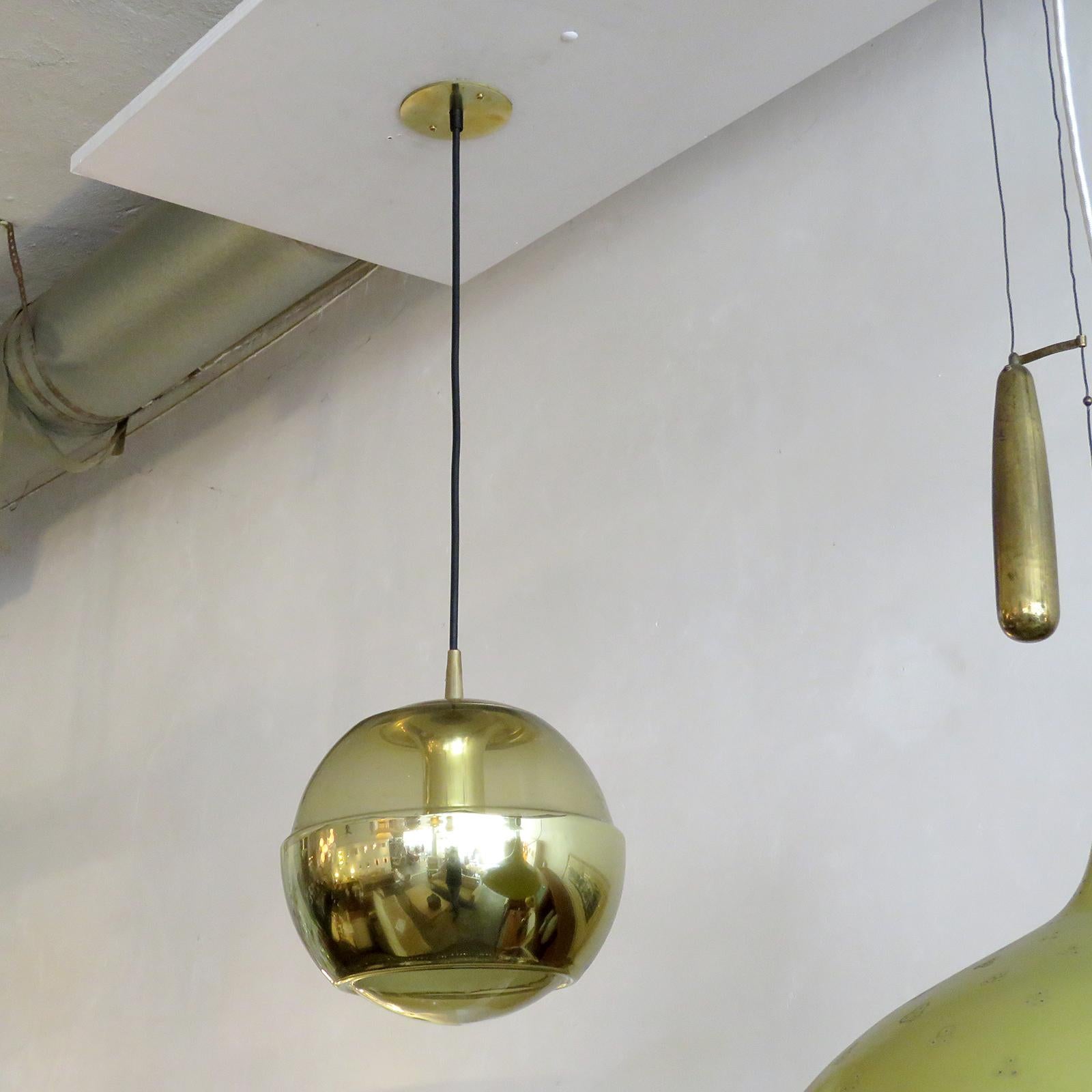 wonderful molded, smoked glass hanging fixtures by Peill & Putzler, with an opaque, brass colored layer across the bottom part of the globes, brass colored hardware and custom solid brass canopy, wired for US standards, one E27 socket per fixture,