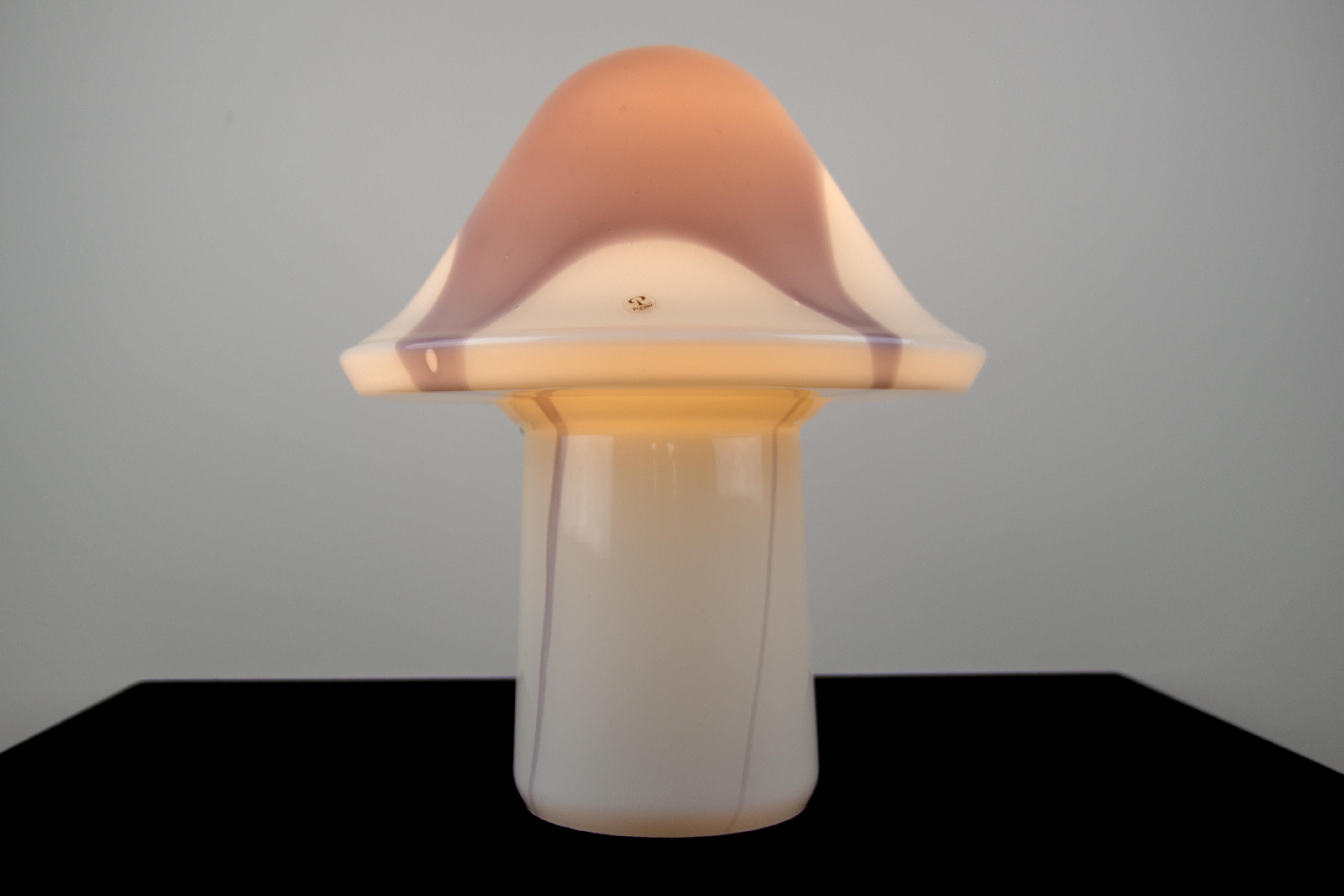 This beautiful and rare model mushroom-shaped table lamp is designed by Peill & Putzler and produced in Germany in the 1970s. The lamp is made of glass and has lilac-grey coloration over the lamp - throughout the shade and body.
One socket for an