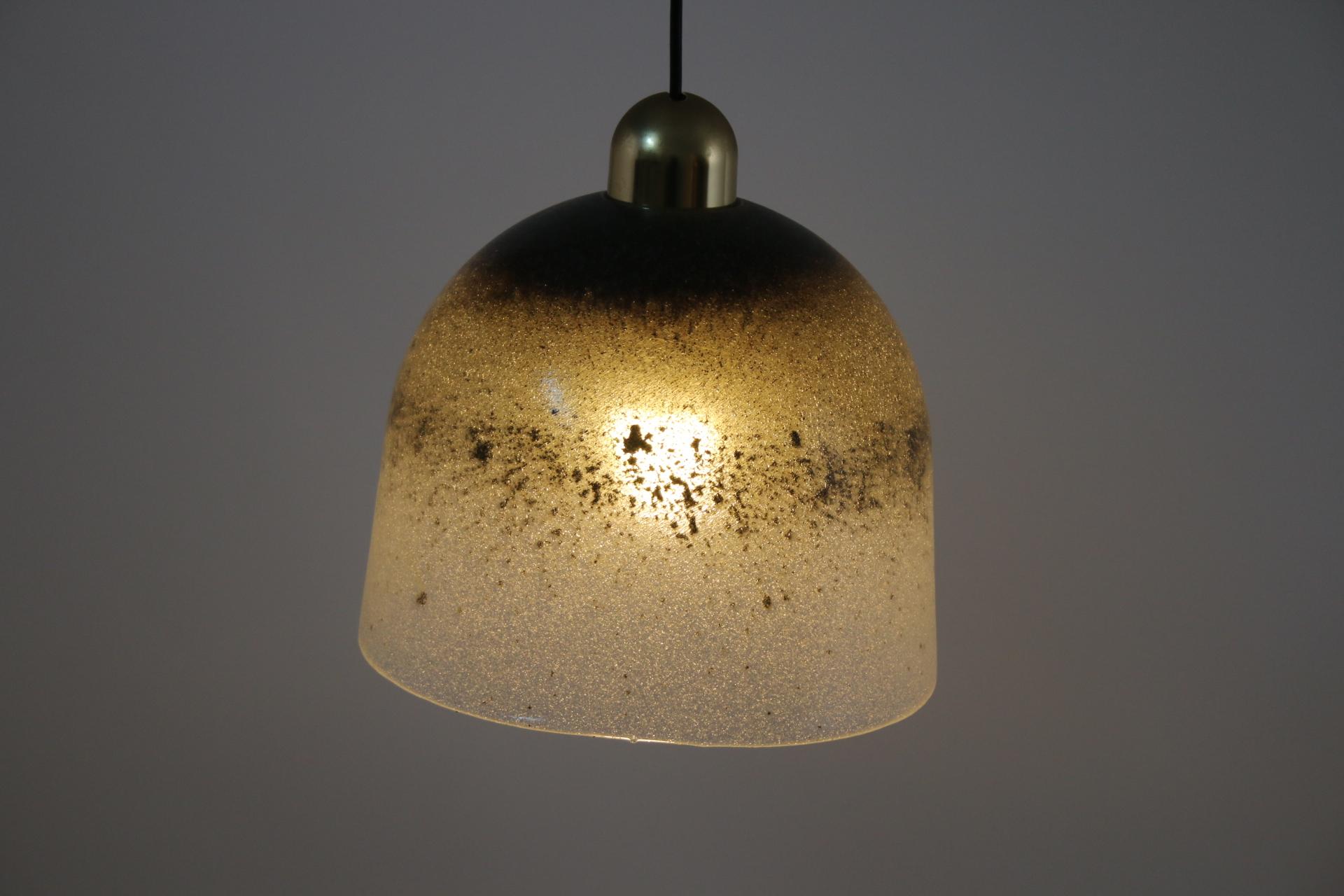 A pendant lamp made of very thick,

heavy glass full of fine bubbles painted in different shades,

reminiscent of the ocean.

When it is on, the lamp gives a very warm and special atmosphere to the room.

The lamp weighs at least 5 to 6 kg.
