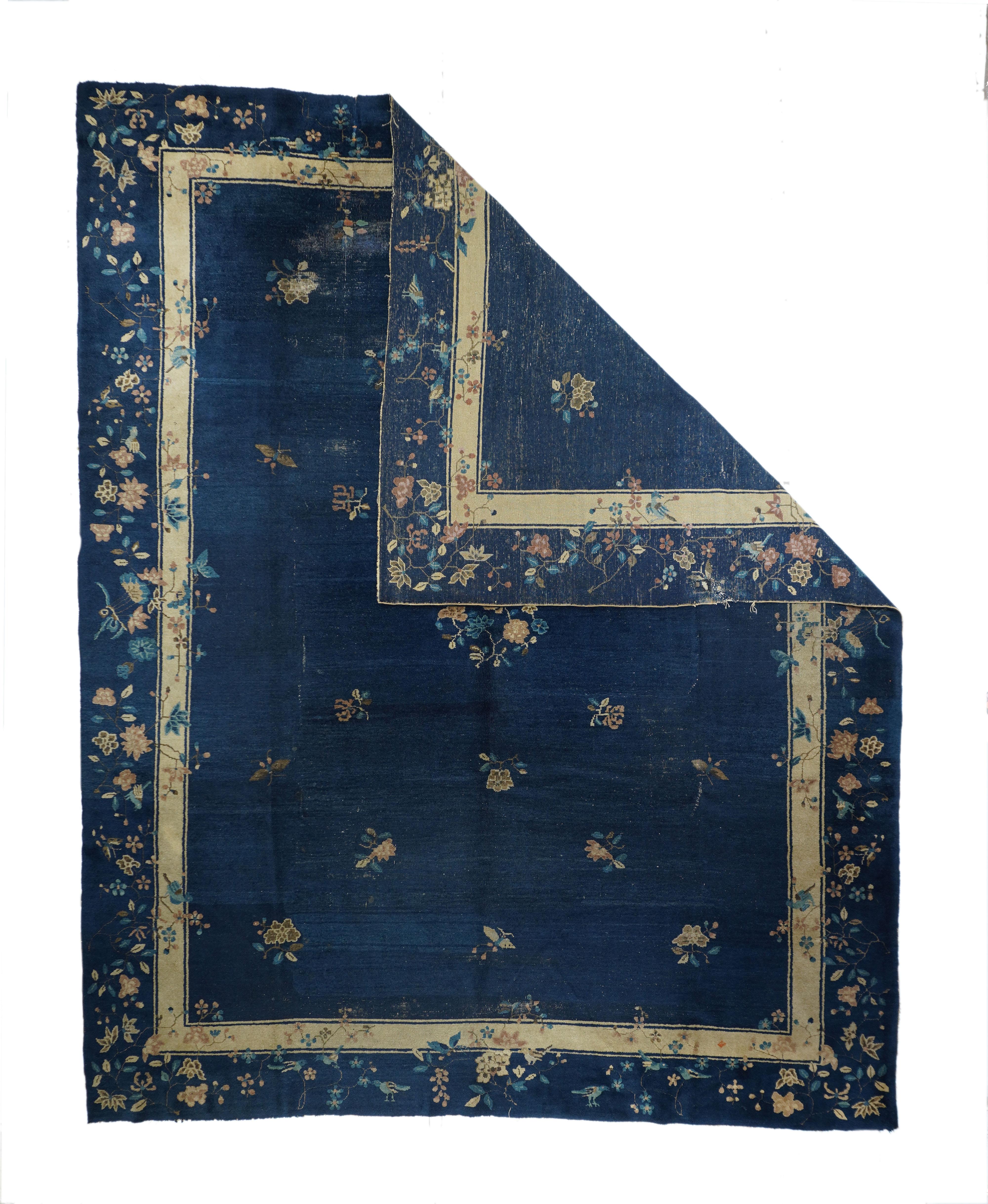 The dark blue ground is centred by a small, round, open medallion of paeony sprays, with widely spaced butterflies and lesser floral sprays on stems. Floral motives of the navy main border flow into the inner secondary. Moderate/medium weave, cotton