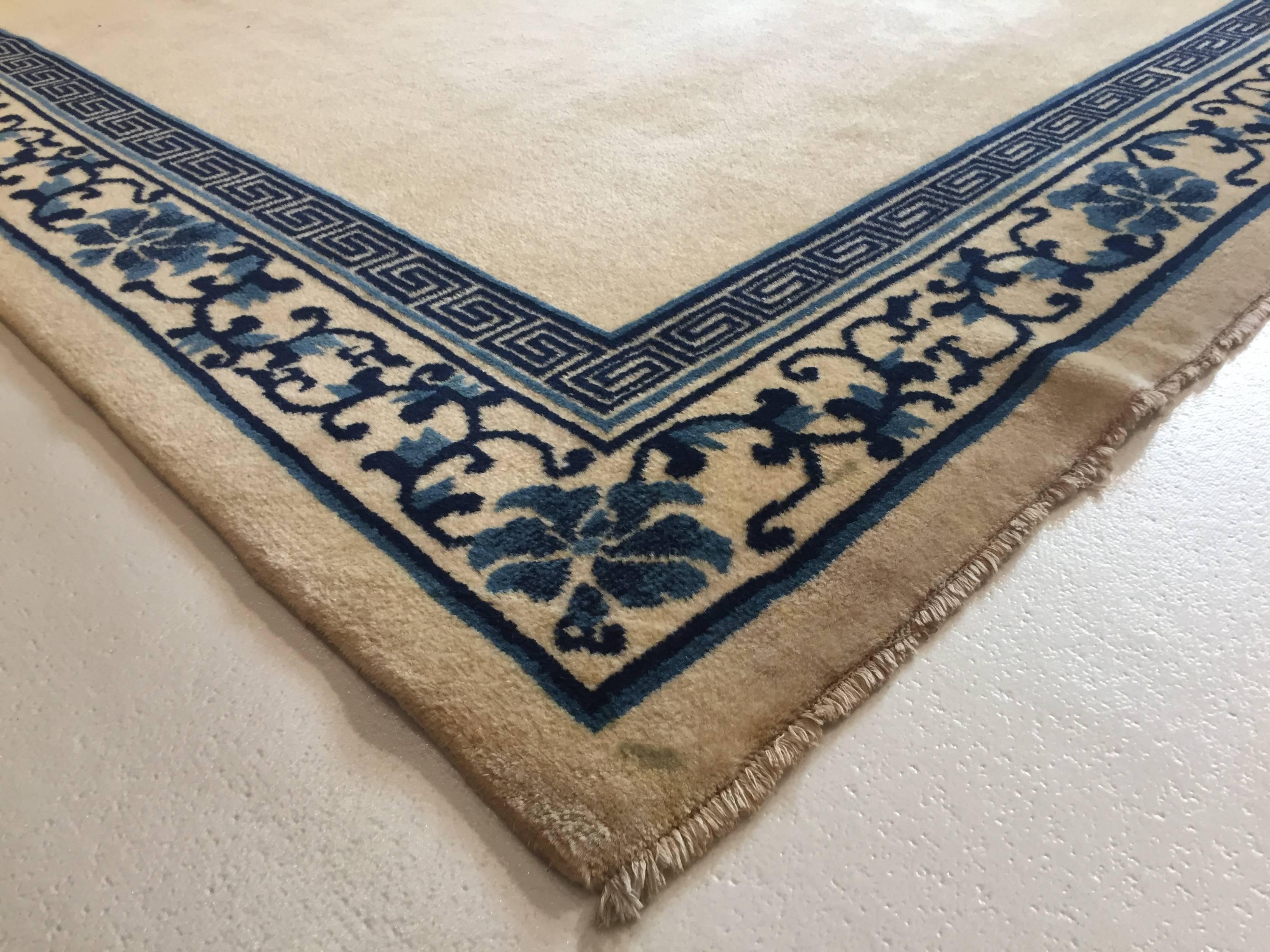 Chinoiseries Tapis chinois pékinois du 20ème siècle à bordure de fleurs blanches et bleues représentant un champ d'empereurs, 1970 en vente