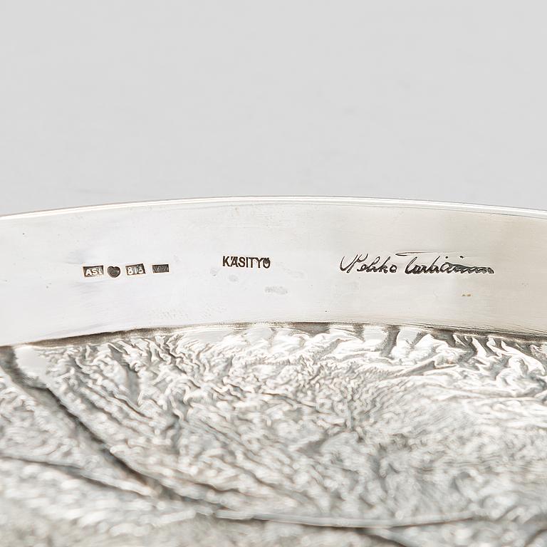 Vassoio in argento sterling di Pekka Turtiainen realizzato a mano con  Tecnica del Samodorok a Helsinki di A. Sirtano, 1970 circa. Firmato dal designer e timbrato dal produttore.
Buono stato
Diam 23 cm maniglie escluse. Peso 324 gr. 