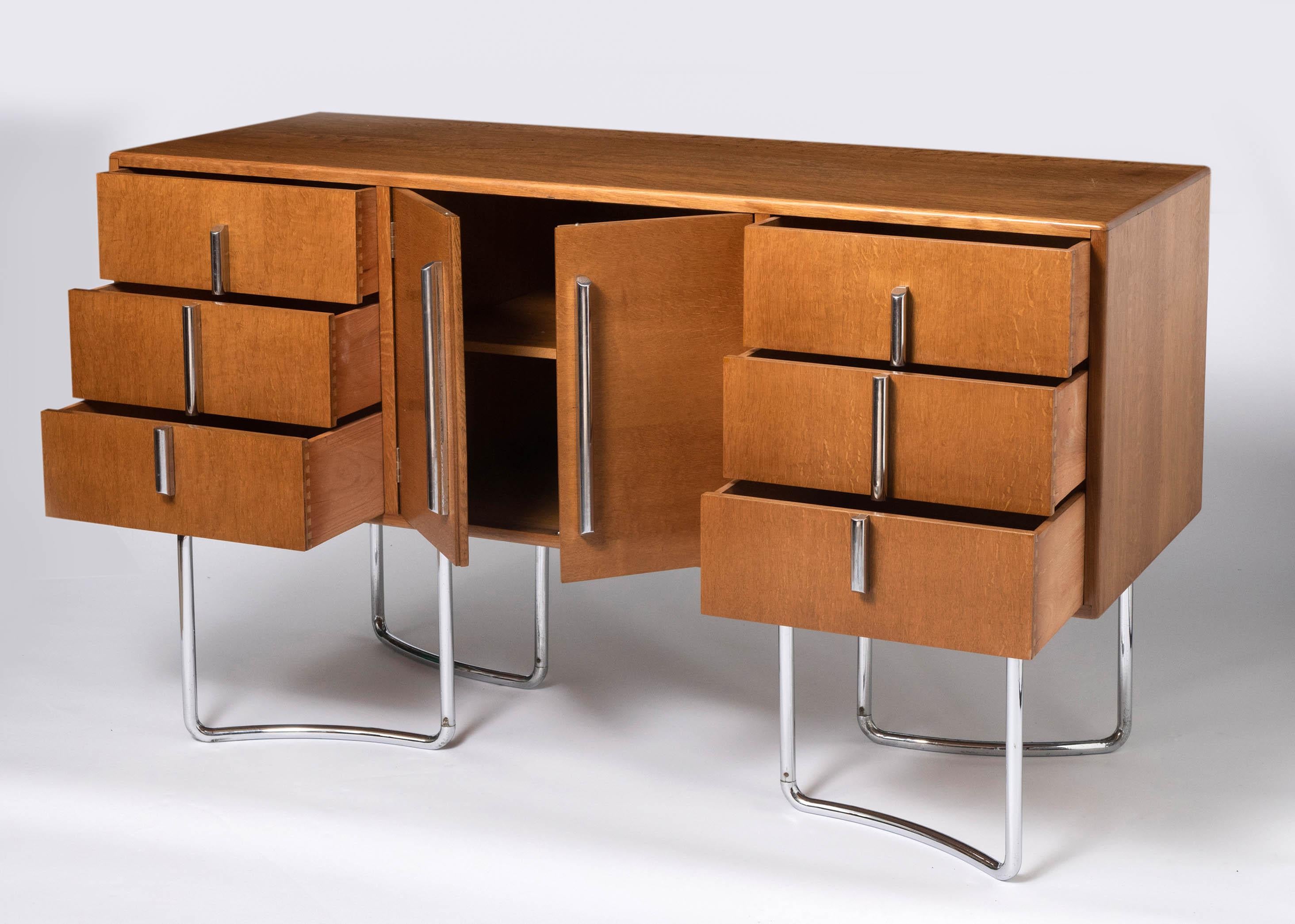 A matching rare P.E.L (Practical Equipment Limited) British modernist sideboard.
Designed by designer/ Architect Oliver Bernard
Veneered plywood body with twin panelled doors flanked by 3 drawers either side. Raised on tubular chrome plated steel