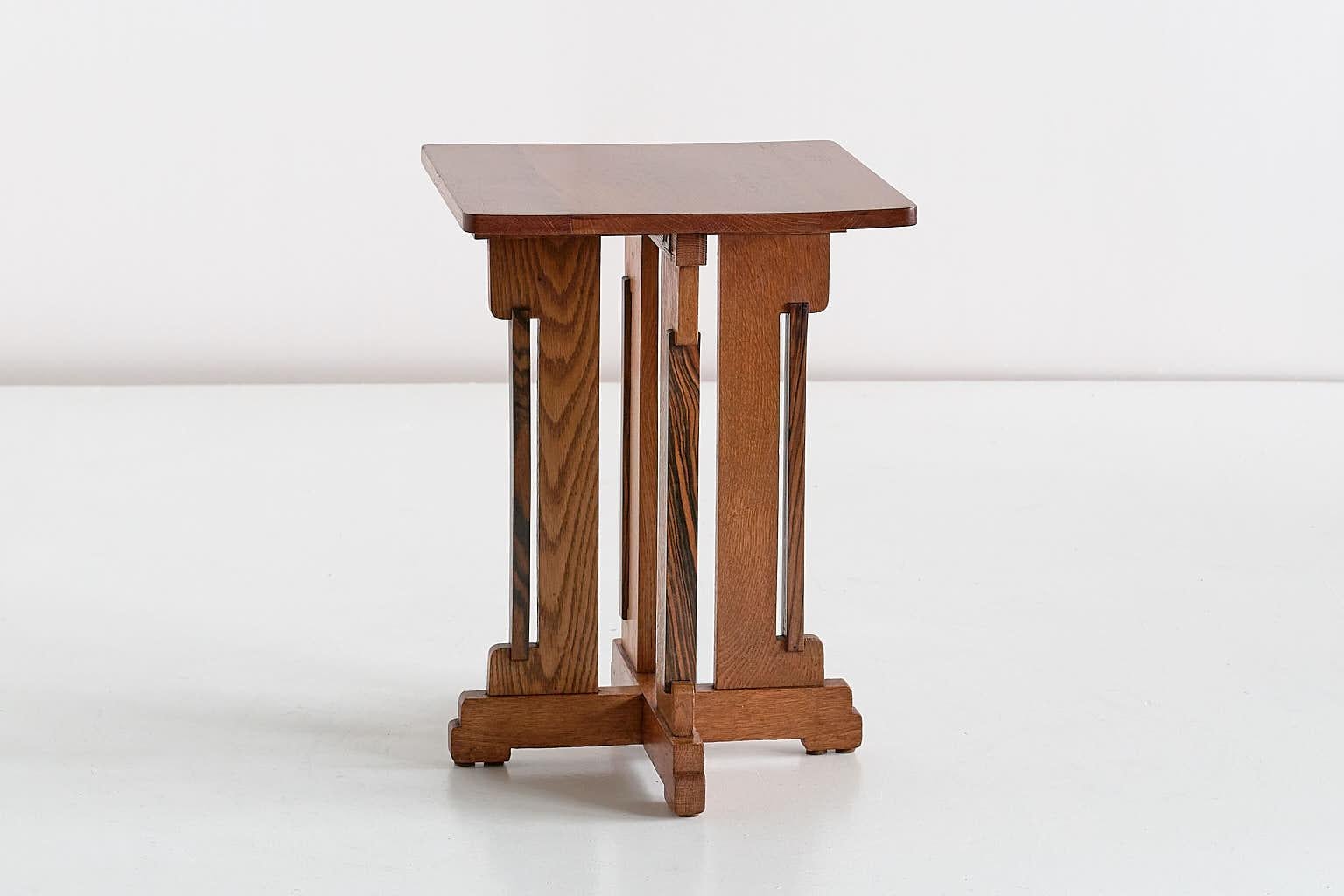 This rare side table was designed by P.E.L. Izeren and produced by the Dutch company Genneper Molen in 1930. The frame and top are made of solid oak, with four contrasting side slats in Macassar Ebony wood. The geometric, tiered base and the