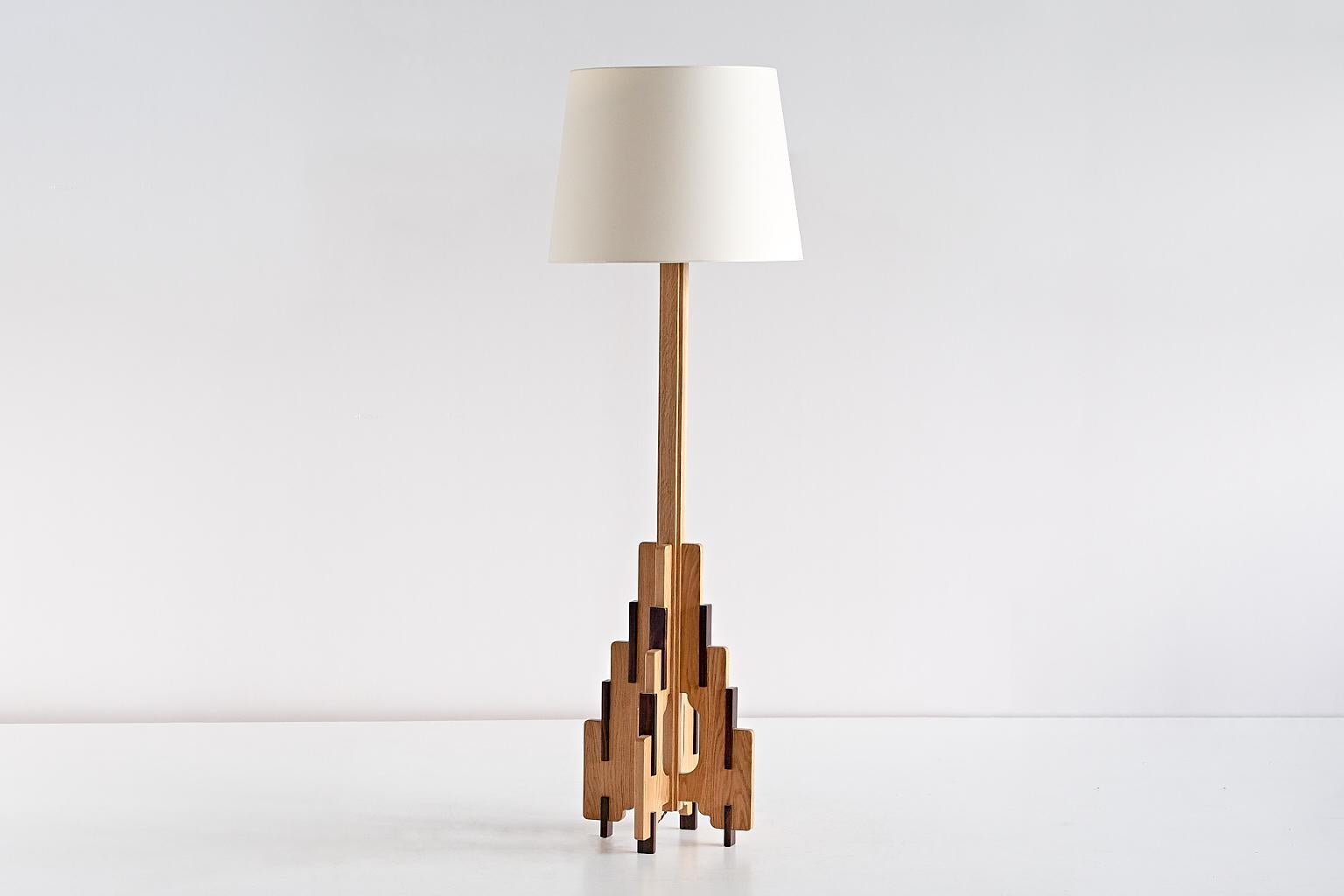 This rare floor lamp was designed by P.E.L. Izeren and produced by the Dutch company Genneper Molen in 1932. The base is made of solid natural oak with interlocking elements in a darker Macassar ebony wood. The new ivory shade offers a nice contrast