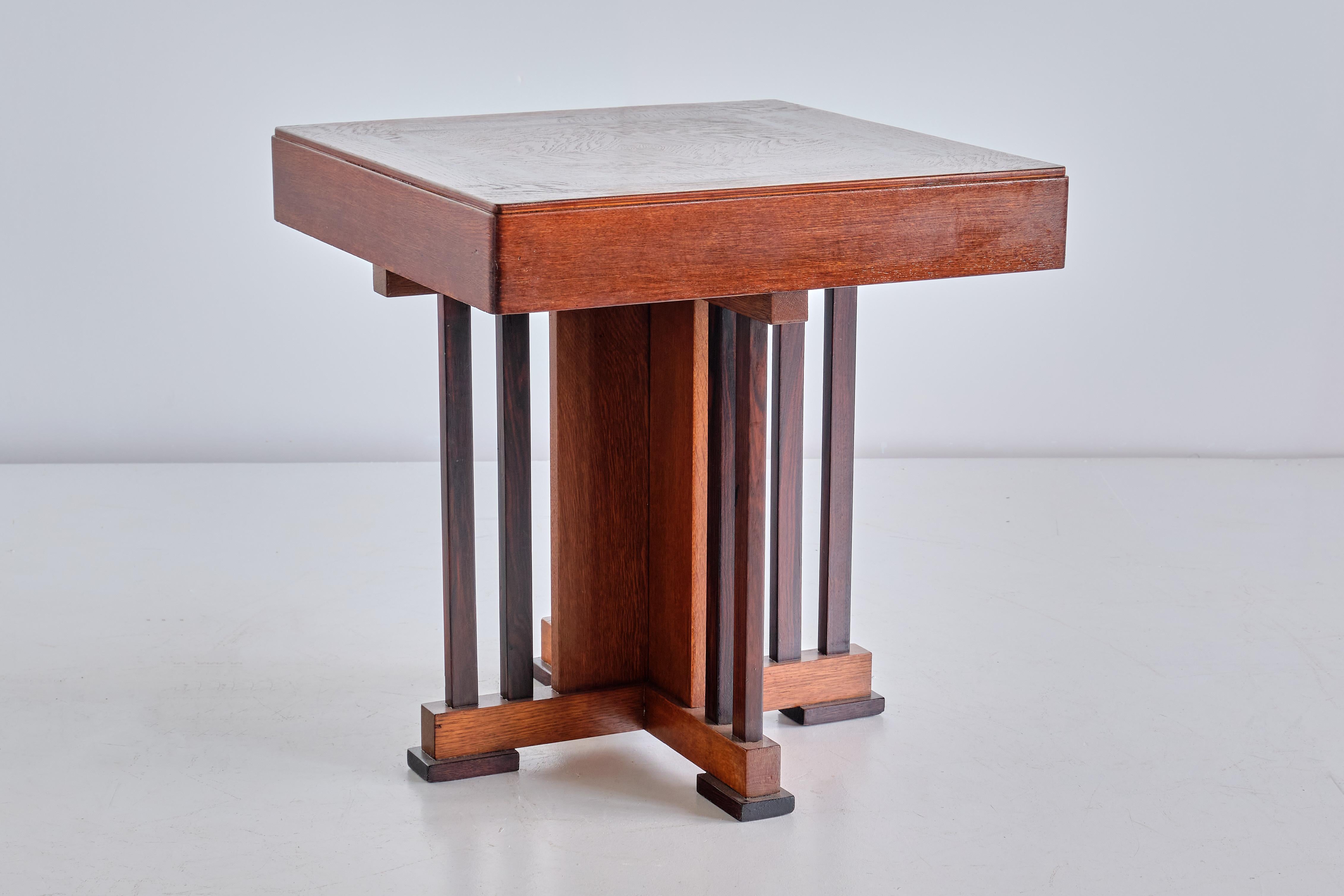 This rare side/occasional table was designed by P.E.L. Izeren and produced by the Dutch company Genneper Molen in 1930. The frame and top are made of solid and veneered oak, with the eight supporting column slats and the rectangular feet in solid